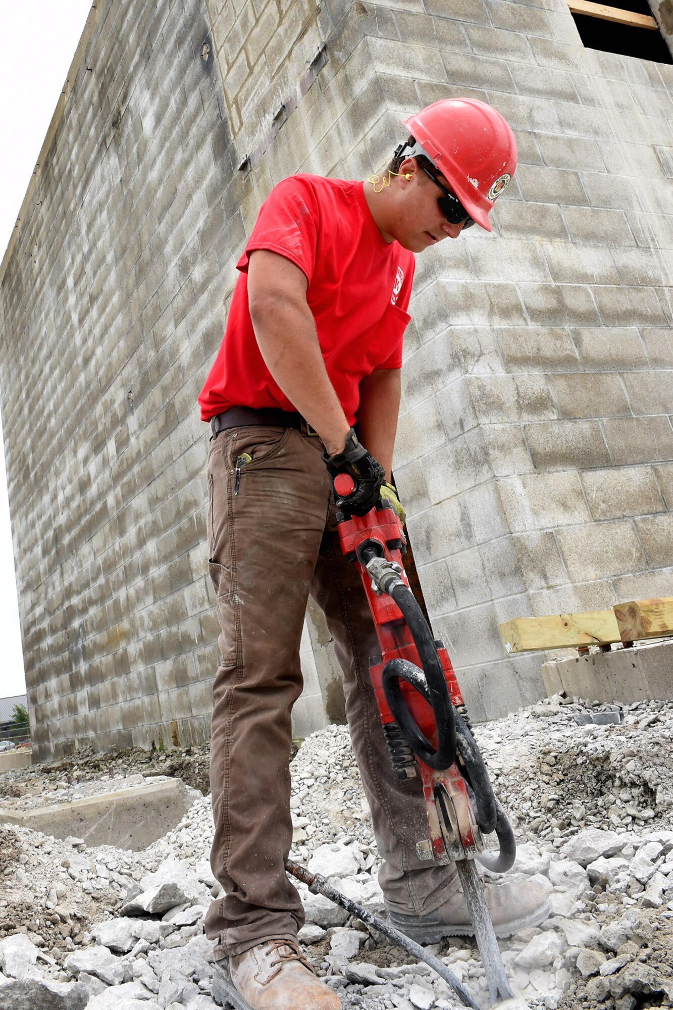 Zack Jamison, a contracted construction laborer, uses a jack hammer to loosen up concrete slabs during construction and renovation of a smoke house at Grissom Air Reserve Base, Ind., June 22, 2015. Grissom's new state of the art smoke house will help provide firefighters with mandated training requirements. (U.S. Air Force photo/Senior Airman Jami K. Lancette) 