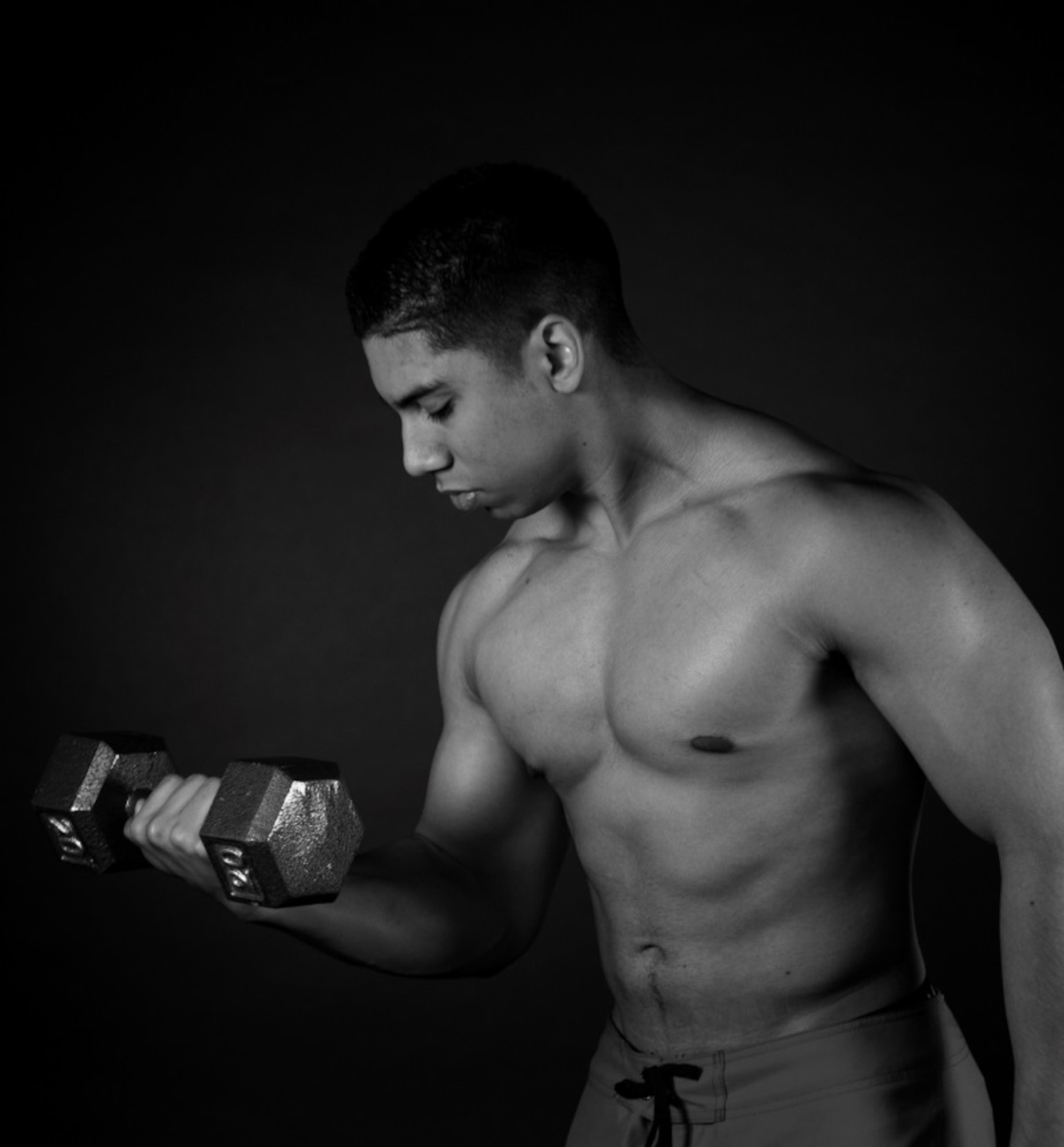 Senior Airman Miguel Amador, 5th Medical Group medical information service technician, lifts a dumbbell at Minot Air Force Base, N.D., Aug. 11, 2015. Amador competes in bodybuilding competitions and has finished as well as second place. (U.S. Air Force photo/Airman 1st Class Christian Sullivan)