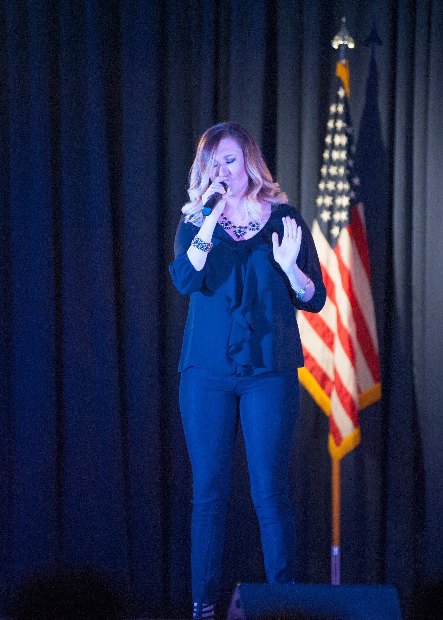 Shannon Garcia, wife of Senior Airman Tyler Garcia, 436th Aircraft Maintenance Squadron, sings “Hurt” by Christina Aguilera during the Air Mobility Command Icon competition August 13, 2015, at the Landings Club on Dover Air Force Base, Del. Garcia finished in first place and won $500. (U.S. Air Force photo/Senior Airman Jared Duhon)