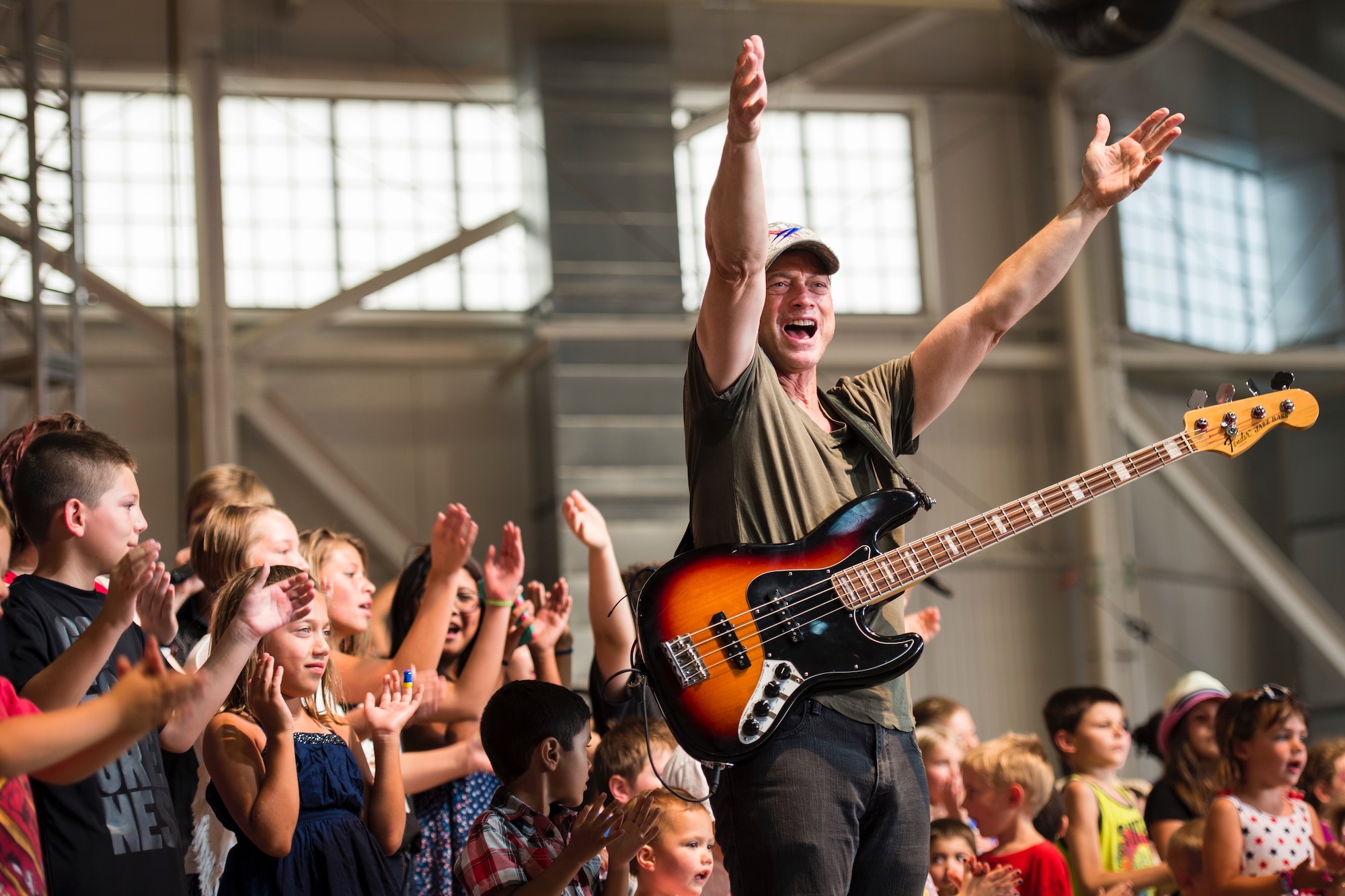 Gary Sinise performs with children from the audience during the Lt. Dan Band performance in Dock 1 at Minot Air Force Base, N.D., Aug. 15, 2015. The Gary Sinise Foundation partnered with the United Service Organizations to perform at Whiteman, Minot and Malmstrom in one weekend. (U.S. Air Force photo/ Airman 1st Class Justin T. Armstrong)
