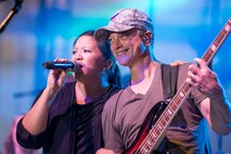 Gary Sinise plays electric bass next to vocalist Mari Anne Jayme during the Lt. Dan Band performance in Dock 1 at Minot Air Force Base, N.D., Aug. 15, 2015. The Gary Sinise Foundation partnered with the United Service Organizations to perform at Whiteman, Minot and Malmstrom in one weekend. (U.S. Air Force photo/ Airman 1st Class Justin T. Armstrong)