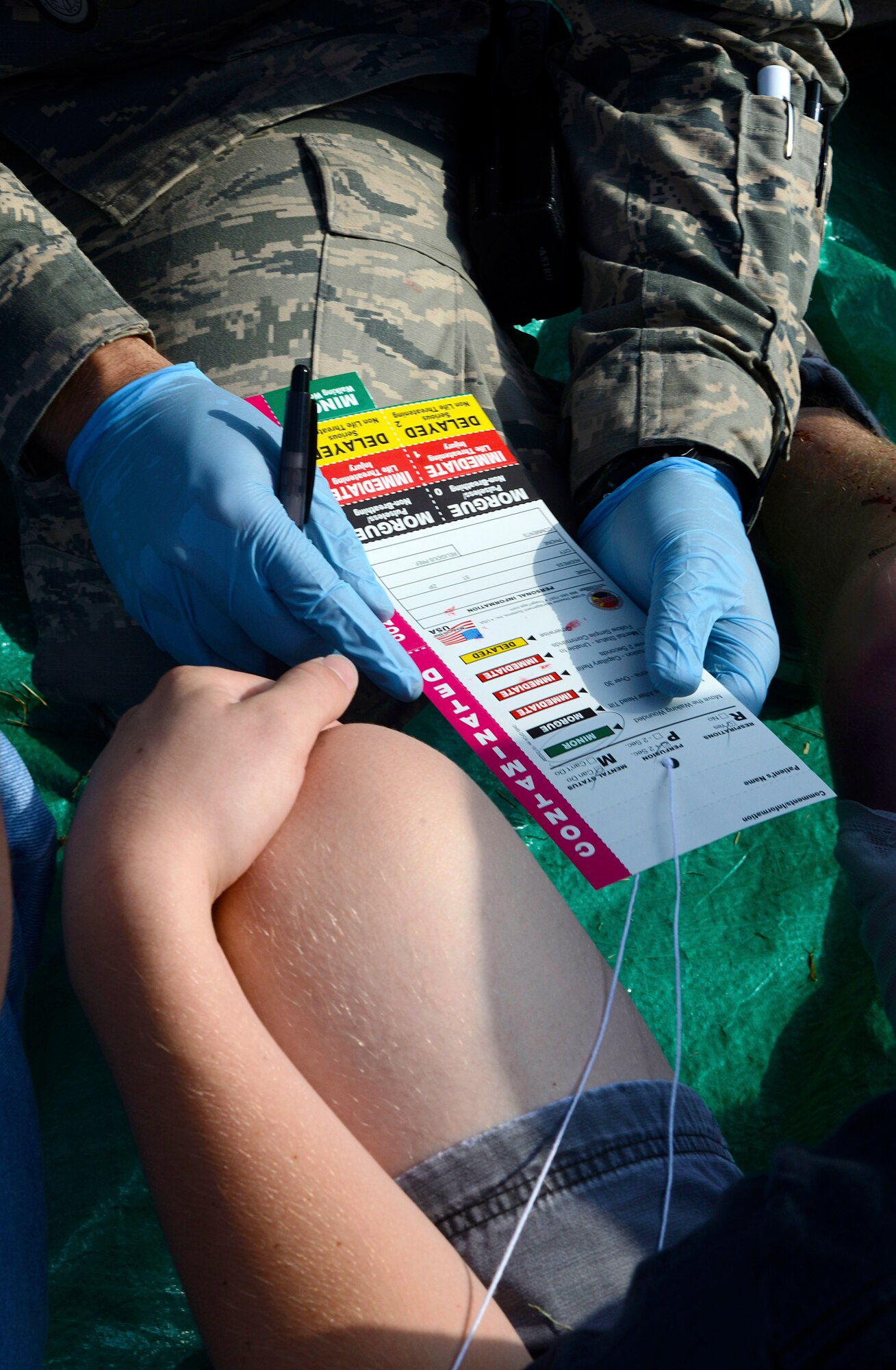An Airman from the 22nd Aerospace Medicine Squadron, tracks a simulated patient’s injuries during a mass-casualty exercise, Aug. 13, 2015, at McConnell Air Force Base, Kan. These cards are used to determine the order in which patients are evacuated from a disaster area for care. (U.S. Air Force photo by Senior Airman Trevor Rhynes)