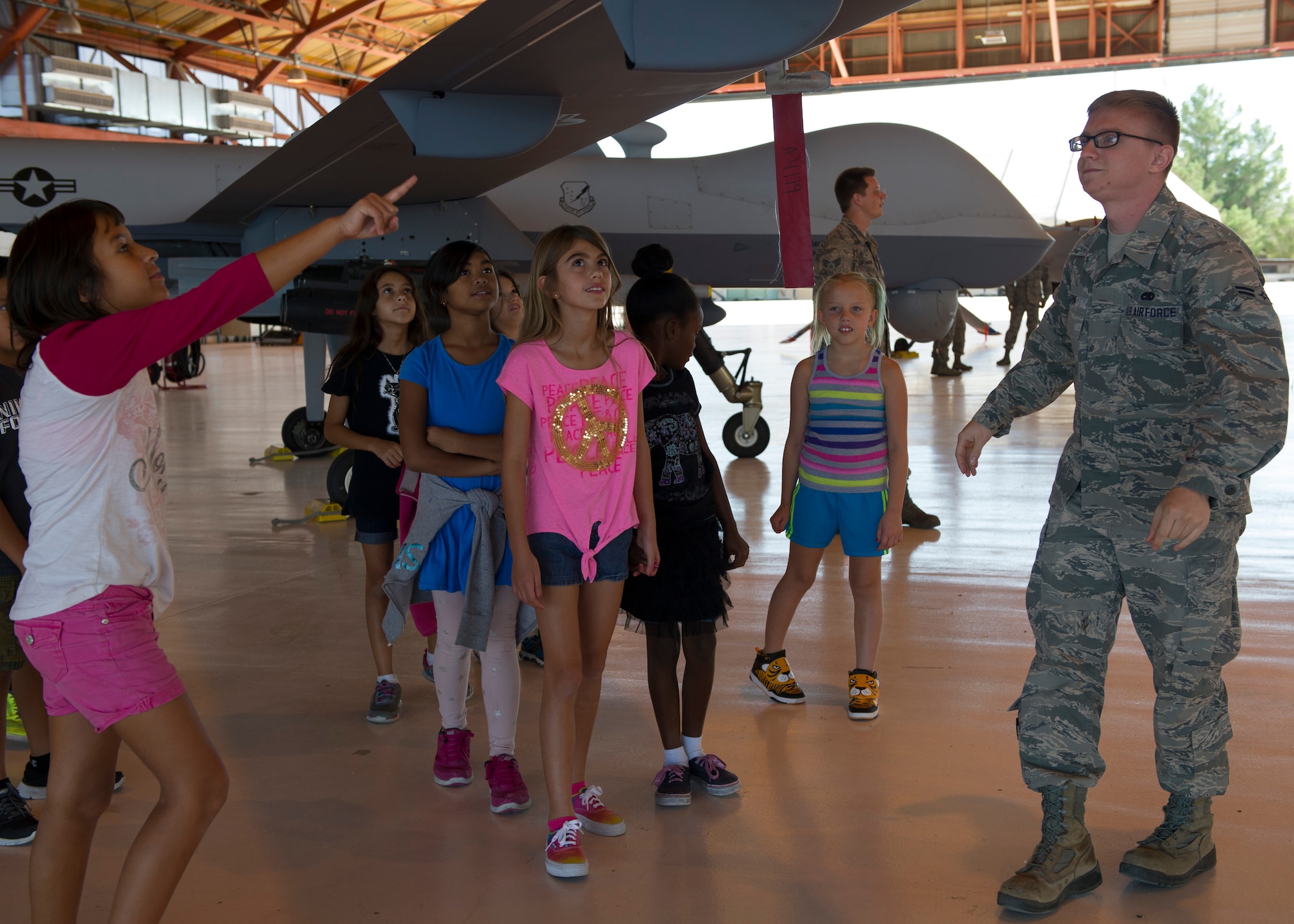 Airman 1st Class Jordan Barton, a 49th Aircraft Maintenance Squadron MQ-9 Reaper avionic systems journeyman, explains the capabilities of the MQ-9 Remotely Piloted Aircraft to the Holloman Youth Center children at Holloman Air Force Base N.M., Aug. 12. The youth center received a hands on tour of Holloman to learn about the various missions Holloman supports. The tour was also sponsored by the Tuskegee Airmen Initiative that supports children’s interest and knowledge in fields of aviation. (U.S. Air Force photo by Senior Airman Leah Ferrante)