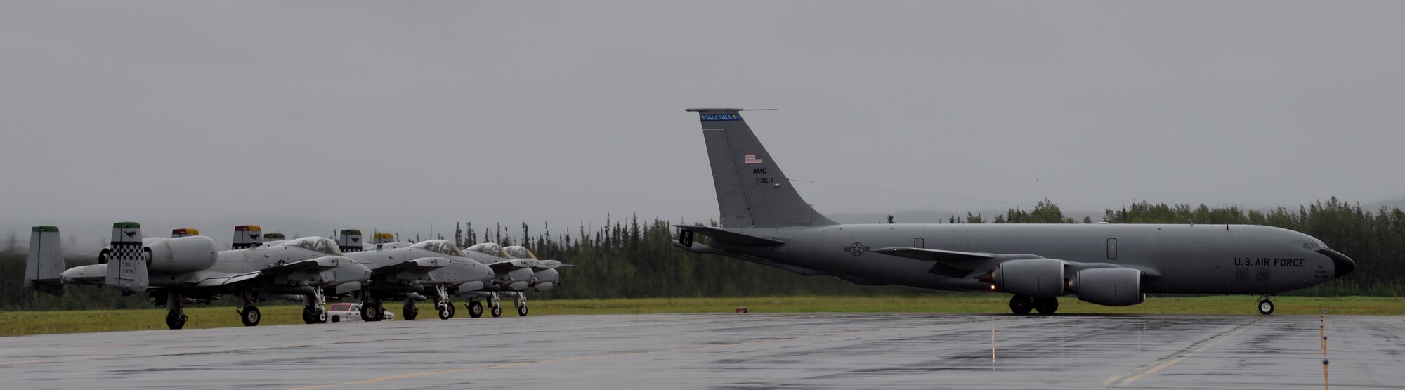 A U.S. Air Force KC-135 Stratotanker deployed from MacDill Air Force Base, Fla., prepares to take of from Eielson Air Force Base, Alaska, as four A-10 Thunderbolt II aircraft from Osan Air Base, Republic of Korea, await their turn to launch Aug. 10, 2015, during RED FLAG-Alaska (RF-A) 15-3. Tanker, transport, fighter and electronic warfare aircraft from multiple countries, service branches, and units are deployed to Eielson for RF-A, a series of Pacific Air Forces commander-directed field training exercises for U.S. and partner nation forces, providing combined offensive counter-air, interdiction, close air support, and large force employment training in a simulated combat environment. (U.S. Air Force photo by Master Sgt. Karen J. Tomasik/Released)