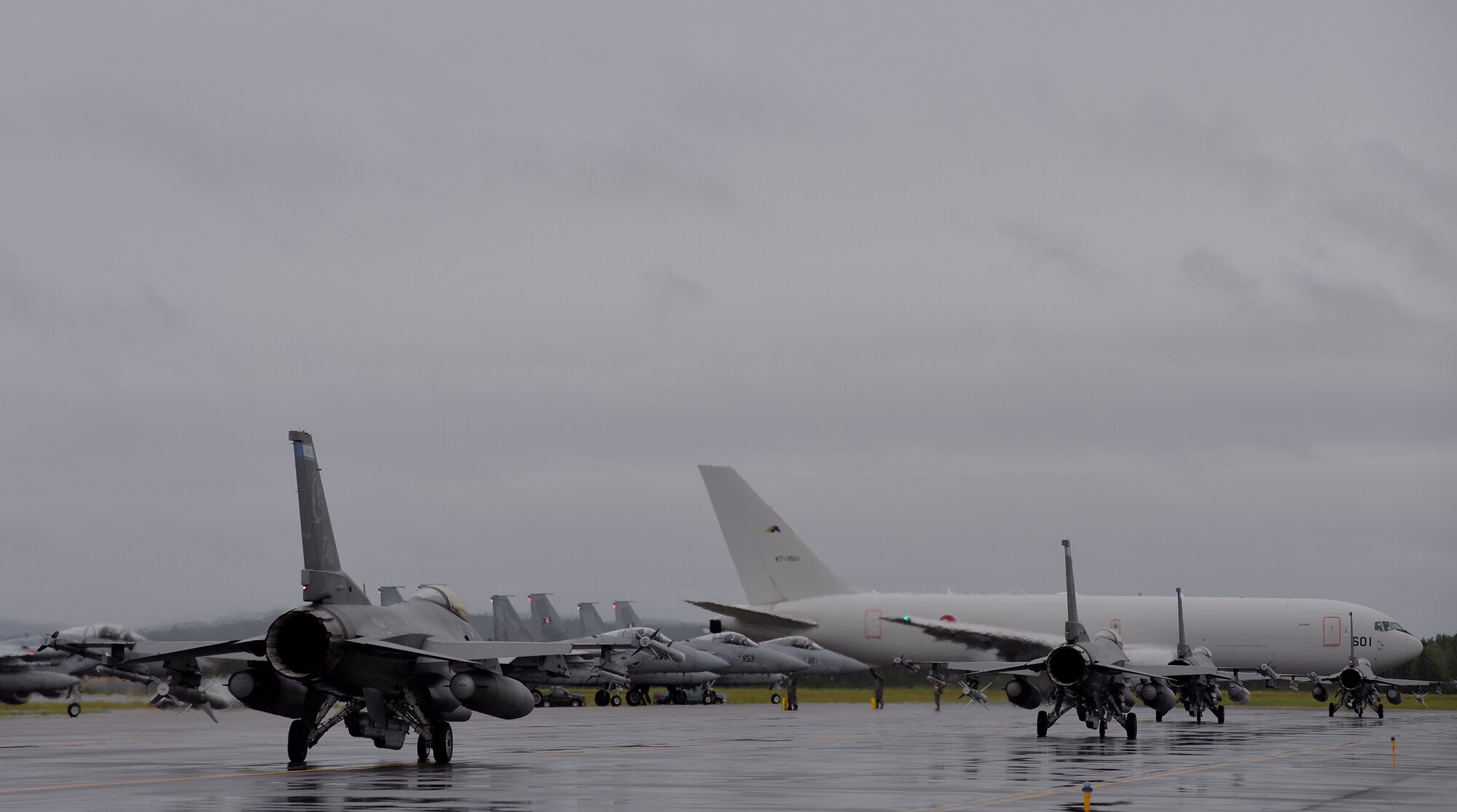 U.S. Air Force F-16 Fighting Falcons assigned to the 148th Fighter Wing from Duluth, Minn., taxi past Japan Air Self-Defense Force (JASDF) F-15J Eagles and a JASDF KC-767 lined up for launch of the first simulated combat sortie of RED FLAG-Alaska (RF-A) 15-3, from Eielson Air Force Base, Alaska, Aug. 10, 2015. Various units from in and outside the Pacific Air Forces (PACAF) area of operations as well as sister service and partner nation units are deployed to Eielson for RF-A, a series of PACAF commander-directed field training exercises for U.S. and partner nation forces, providing combined offensive counter-air, interdiction, close air support, and large force employment training in a simulated combat environment. (U.S. Air Force photo by Master Sgt. Karen J. Tomasik/Released)