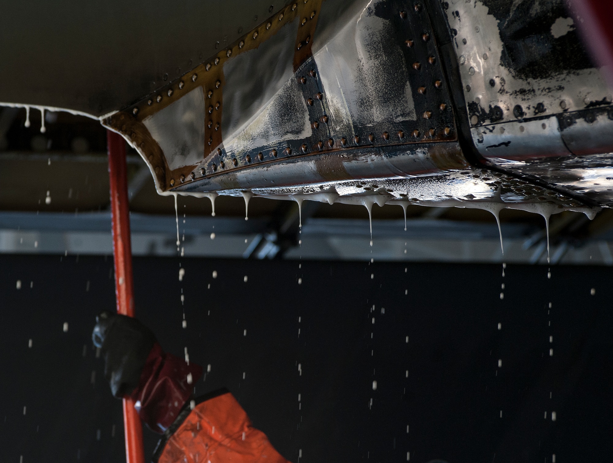 A 5th Maintenance Squadron crew chief scrubs under the wing of a B-52H Stratofortress at Minot Air Force Base, N.D., Aug. 4, 2015. Aircraft washes are commonly conducted in the base’s double phase dock and last and average of two days. (U.S. Air Force photos/Senior Airman Stephanie Morris)