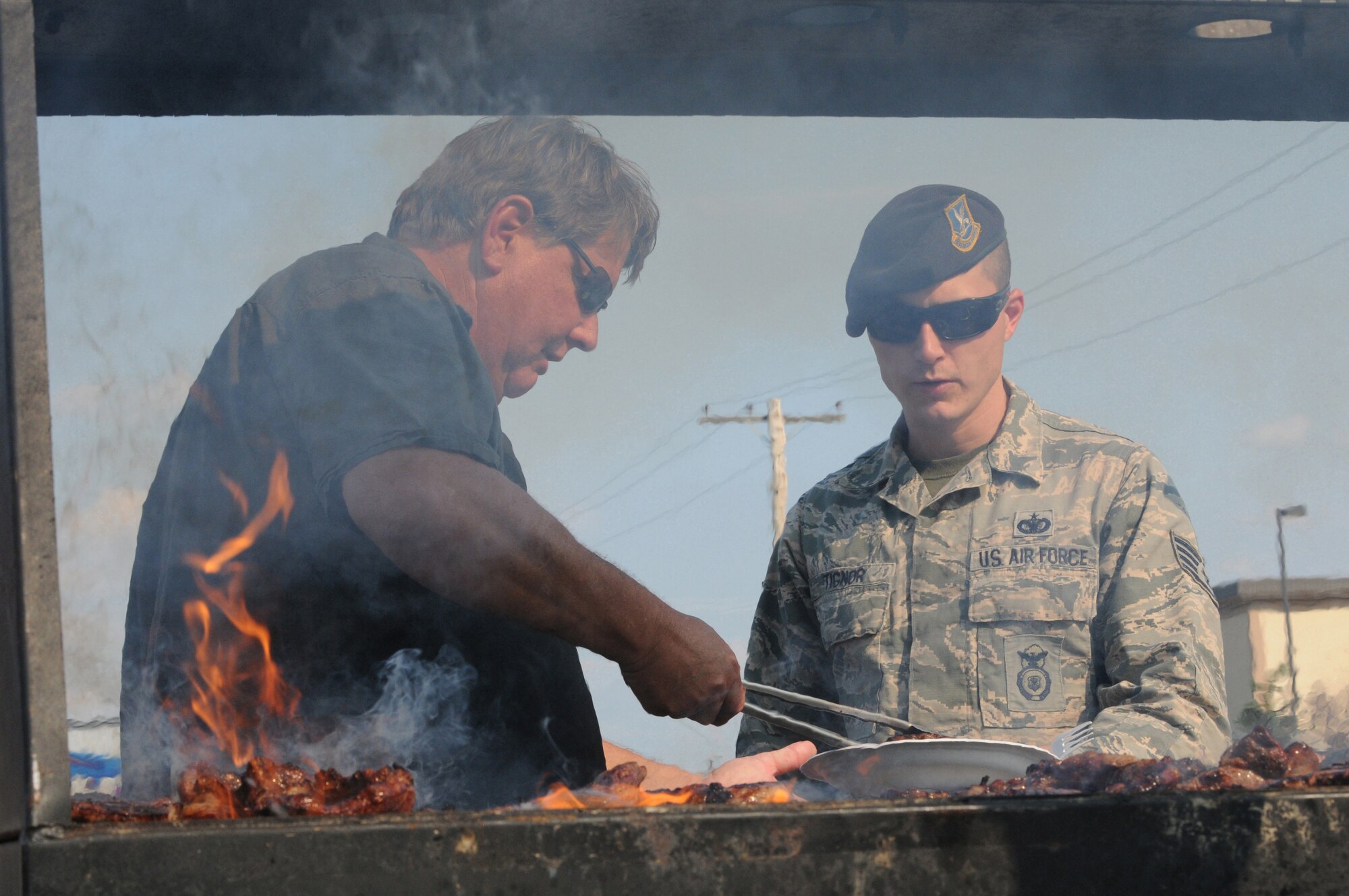 Tony Booth of the Steak Team Mission serves an Airman a steak at Eielson Air Force Base, Alaska, Aug. 7, 2015.  The Steak Team Mission served 2,000 steaks to Airmen from Eielson and military units participating in RED FLAG-Alaska 15-3 to show appreciation for their service.  (U.S. Air Force photo by Master Sgt. Ralph J. Kapustka/Released)