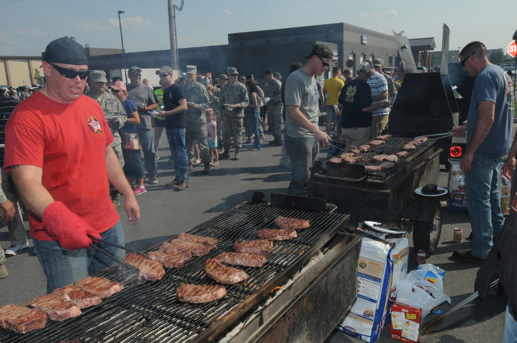 The Steak Team Mission and Eielson Air Force Base, Alaska, volunteers serve up steaks during a base steak feed, Aug. 7, 2015.  The Steak Team Mission served 2,000 steaks to Airmen from Eielson AFB and military units participating in RED FLAG-Alaska 15-3 to show appreciation for their service.  (U.S. Air Force photo by Master Sgt. Ralph J. Kapustka/Released)