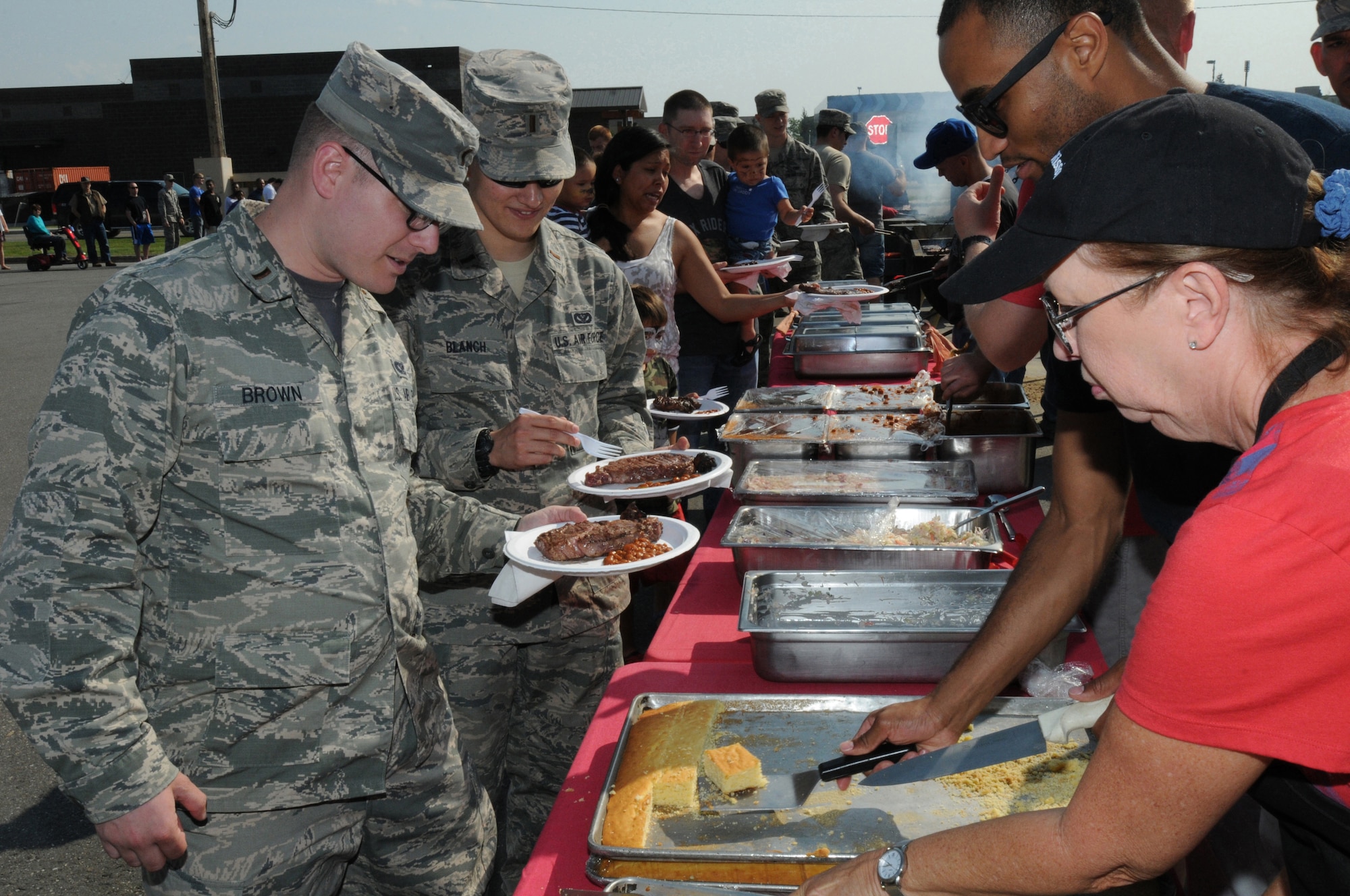 Airmen and their families wait in line during a steak feed at Eielson Air Force Base, Alaska, Aug. 7, 2015.  The Steak Team Mission served 2,000 steaks to Airmen from Eielson and military units participating in RED FLAG-Alaska 15-3 to show appreciation for their military service.  (U.S. Air Force photo by Master Sgt. Ralph J. Kapustka/Released)