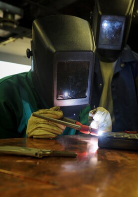 Airman 1st Class Devin Painter, 5th Maintenance Squadron aircraft metals technician, welds the edge of a piece of metal at Minot Air Force Base, N.D., Aug. 14, 2015. The base welding shop repairs a wide array of base equipment including aircraft and vehicle parts. (U.S. Air Force photo/Senior Airman Stephanie Morris)
