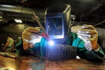 Airman 1st Class Devin Painter, 5th Maintenance Squadron aircraft metals technician, welds the edge of a piece of metal at Minot Air Force Base, N.D., Aug. 14, 2015. The base welding shop repairs a wide array of base equipment including aircraft and vehicle parts. (U.S. Air Force photo/Senior Airman Stephanie Morris)