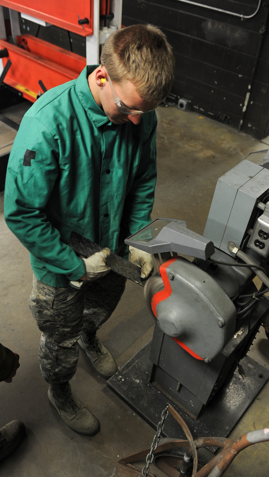 Airman 1st Class Devin Painter, 5th Maintenance Squadron aircraft metals technician, grinds the edges of a piece of metal at Minot Air Force Base, N.D., Aug. 14, 2015. The welding shop is able to fabricate a wide array of metal projects by utilizing tungsten inert gas and metal inert gas welding machines, grinders and plasma cutters. (U.S. Air Force photos/Senior Airman Stephanie Morris)