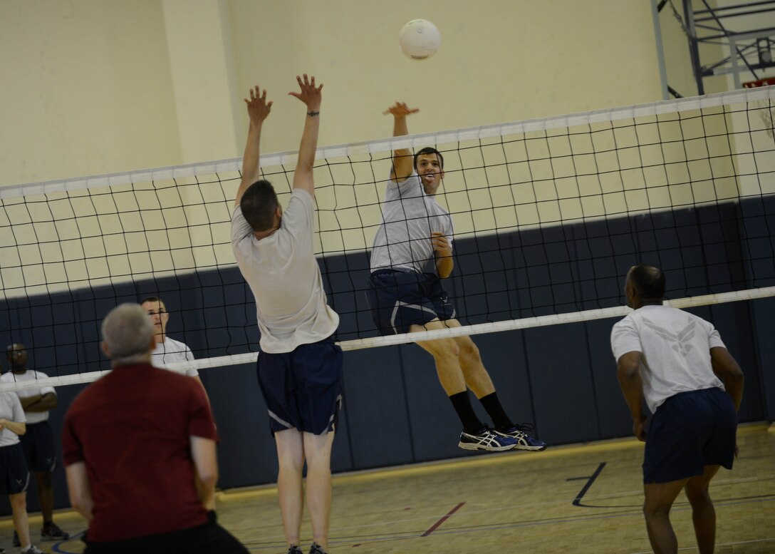 U.S. Air Force Senior Airman John Del Guidice, 31st Aircraft Maintenance Squadron weapons load crew member, spikes the ball during a volleyball match, Aug. 17, 2015, at Aviano Air Base, Italy. ALS classes play against base leadership in friendly volleyball a match, which provides interaction with leadership outside normal work environment. (U.S. Air Force photo by Staff Sgt. Evelyn Chavez/Released)