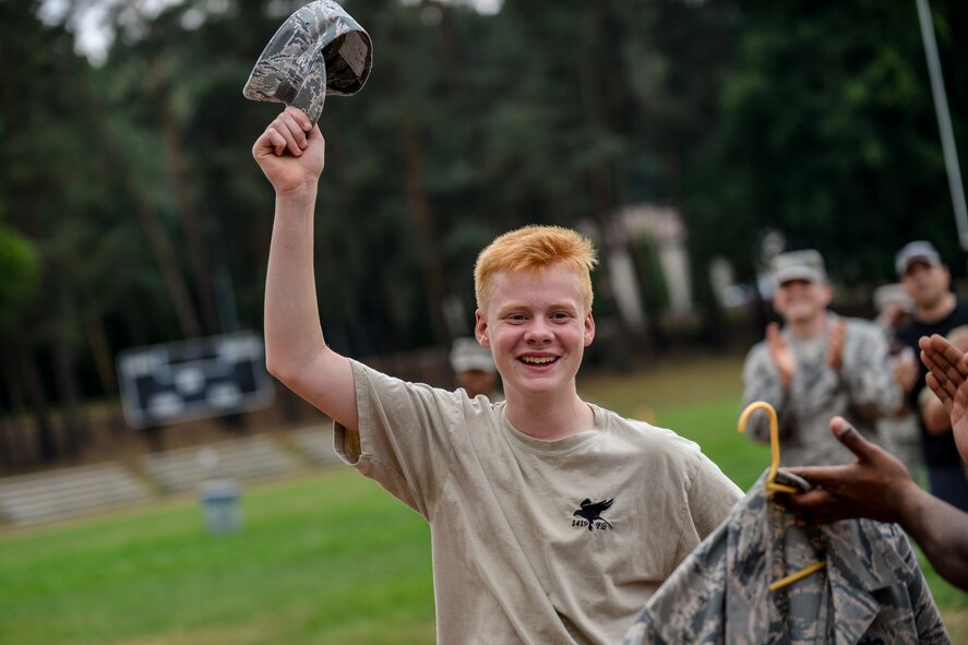 Jack Mottram, Royal Air Force Air Training Corps cadet, receives an Airman Battle Uniform cover from a Kisling NCO Academy instructor Aug. 10, 2015, on Vogelweh, Germany. It is tradition within the RAF to collect and exchange hats from different missions. (U.S. Air Force photo/Senior Airman Nicole Sikorski)