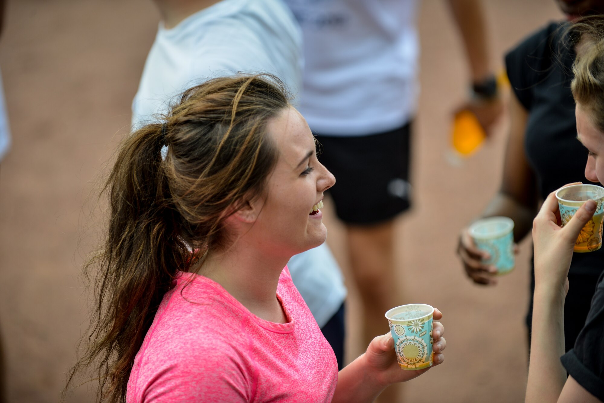 Jade Thomas, Royal Air Force Air Training Corps cadet, laughs with her teammates during a break from an obstacle course Aug. 10, 2015, on Vogelweh, Germany. The cadets completed four rounds of tire flips, football drills, speed work and sprints during the course, which was geared around developing leadership skills. (U.S. Air Force photo/Senior Airman Nicole Sikorski) 