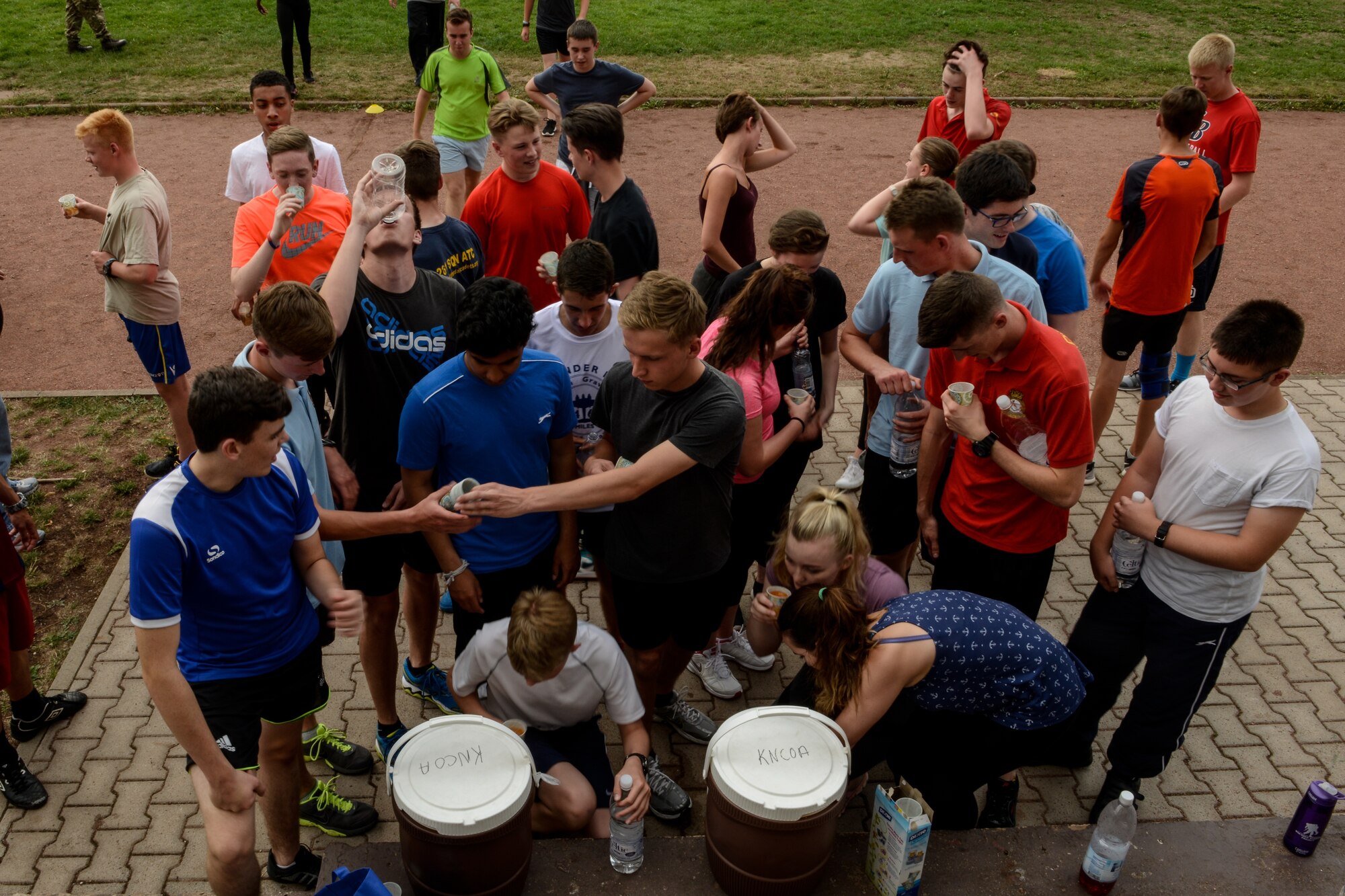Royal Air Force Air Training Corps cadets drink water after an obstacle course Aug. 10, 2015, on Vogelweh, Germany. The cadets completed four rounds of tire flips, football drills, speed work and sprints during the course hosted by the Kisling NCO Academy. (U.S. Air Force photo/Senior Airman Nicole Sikorski) 