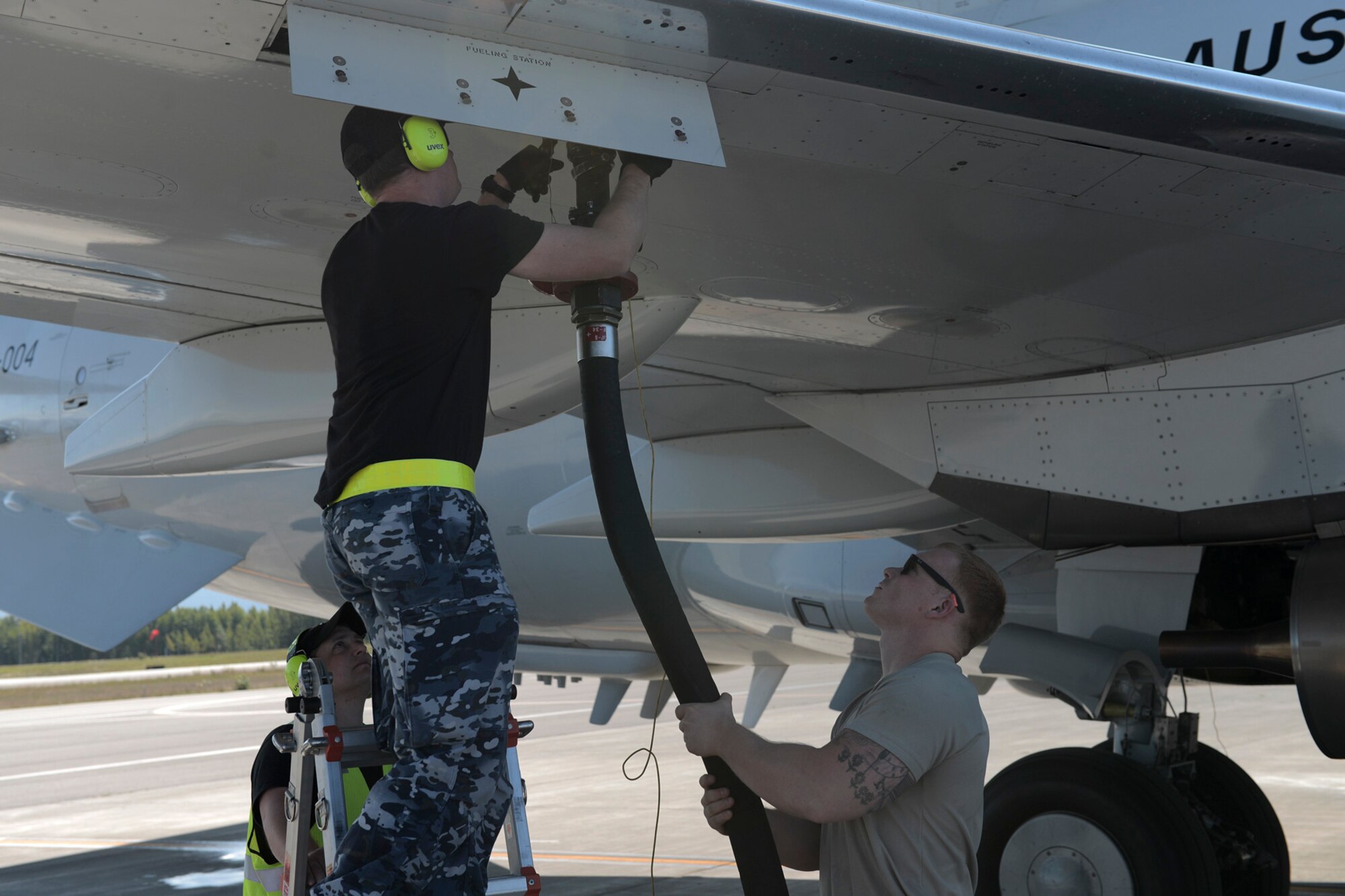 (LEFT) Mark Dunn and (CENTER) Kayne Markham, Royal Australian Air Force leading aircraftsman with the 42 Wing, 2 Squadron, work with U.S. Air Force Senior Airman Reinhardt Andersen to refuel an E-3 Sentry during RED FLAG-Alaska at Joint Base Elmendorf-Richardson, Alaska, Aug. 14, 2015. Andersen, a fuels distribution operator with the 18th Logistical Readiness Squadron out of Kadena Air Base, Japan, is just one member with the Pacific Air Forces deployed to Alaska in support of RFA, gaining experience in multi-national and joint operations. (U.S. Air Force photo by Staff Sgt. Cody H. Ramirez/Released)