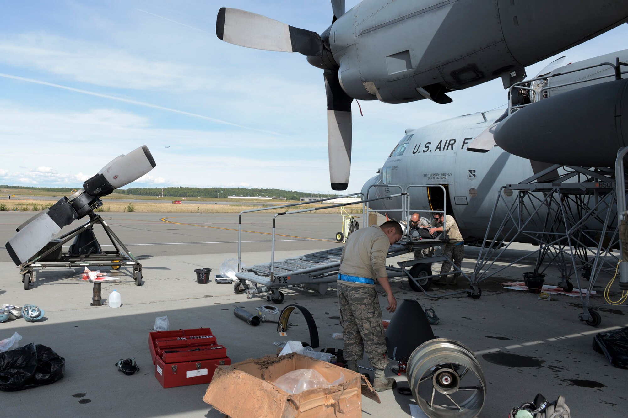 Airmen with the 374th Aircraft Maintenance Squadron refer to instructions on replacing a C-130 Hercules propeller during RED FLAG-Alaska at Joint Base Elmendorf-Richardson, Aug. 13, 2015. Maintainers, depending on the needs of the aircraft, work up to 16 hours a day to ensure the C-130 Hercules are ready for flights everyday during RFA. (U.S. Air Force photo by Staff Sgt. Cody H. Ramirez/Released)