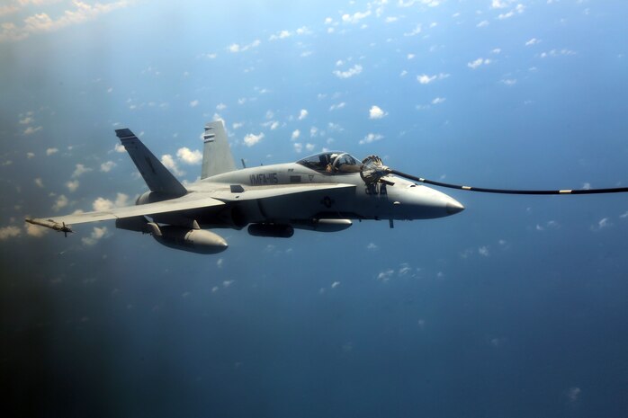 An F/A-18 Hornet attaches to a fuel line of a KC-130J Super Hercules during aerial refueling training over the Atlantic Ocean, Aug. 13, 2015. Marine Fighter Attack Squadron 115 joined Marine Aerial Refueler Squadron 252 for aerial refueling training to enhance naval aviator’s proficiency skills with the refueling procedures. VMFAT-115 is based at Marine Corps Air Station Beaufort, South Carolina and VMGR-252 is based at Marine Corps Air Station Cherry Point, North Carolina. (U.S. Marine Corps photo by Cpl. N.W. Huertas/Released)
