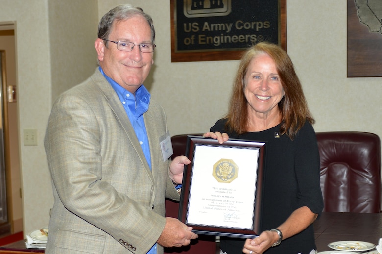 The Honorable Jo-Ellen Darcy, assistant secretary of the Army for Civil Works, presents Mike Wilson, U.S. Army Corps of Engineers Nashville District deputy for Programs and Project Management, with a certificate recognizing his 40 years of service during a stakeholder meeting with the Mississippi River Commission onboard the Motor Vessel Mississippi while docked in Clarksville, Tenn., Aug. 11, 2015.