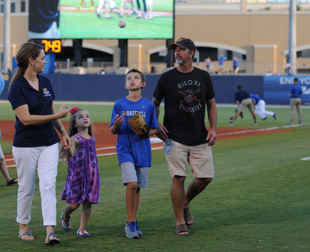 Col. Michele Edmondson, 81st Training Wing commander, tosses a baseball to her family, Jacqueline, Callahan and Dave McGowan, as they exit the field during the Biloxi Shuckers Minor League Baseball game Aug. 15, 2015, at MGM Park, Biloxi, Miss. Edmondson threw an opening pitch prior to the start of the game. (U.S. Air Force photo by Kemberly Groue)