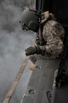 California Army National Guard Staff Sgt. Alexander Martinez, crew chief from the 1106 Theater Aviation Sustainment Maintenance Group, operates on a UH-60 Black Hawk over the Fork Complex in Shasta and Trinity Counties, California, Aug. 17, 2015. 