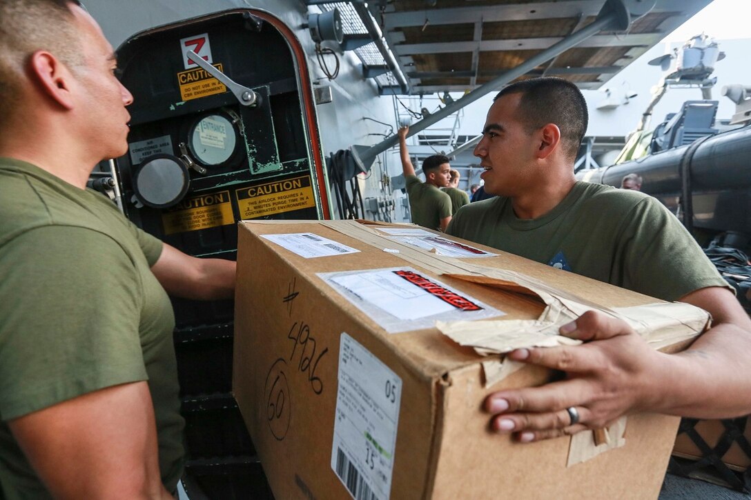 GULF OF ADEN (Aug. 15, 2015) U.S. Marine Cpl. Oscar Sotomeza, right, helps sort mail received from the USNS John Ericsson (T-AO 194) during a replenishment-at-sea. Sotomeza is a rifleman with Headquarters and Service Company, Battalion Landing Team 3rd Battalion, 1st Marine Regiment, 15th Marine Expeditionary Unit.  The 15th Marine Expeditionary Unit is embarked aboard the amphibious transport dock ship USS Anchorage (LPD 23), part of the Essex Amphibious Ready Group, and is deployed in support of maritime security operations and theater security cooperation efforts in the U.S. 5th Fleet area of operations.  (U.S. Marine Corps photo by Sgt. Steve H. Lopez/ Released)