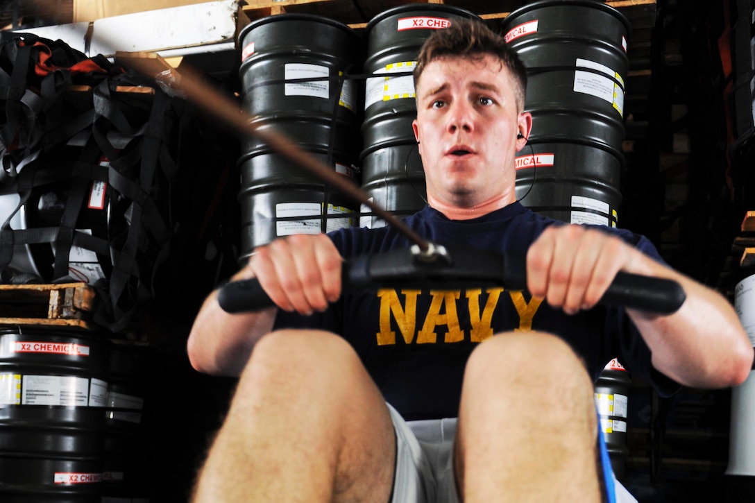 U.S. Navy Lt. Michael Smallwood rows 500 meters during the Teddy Challenge in the hangar bay on the aircraft carrier USS Theodore Roosevelt in the Arabian Gulf, Aug. 16, 2015. The challenge involved completing a 500-meter row, 30 power cleans and presses, 30 kettle bell swings, 30 burpees and another 500-meter row. U.S. Navy photo by Petty Officer 3rd Class Jennifer Case