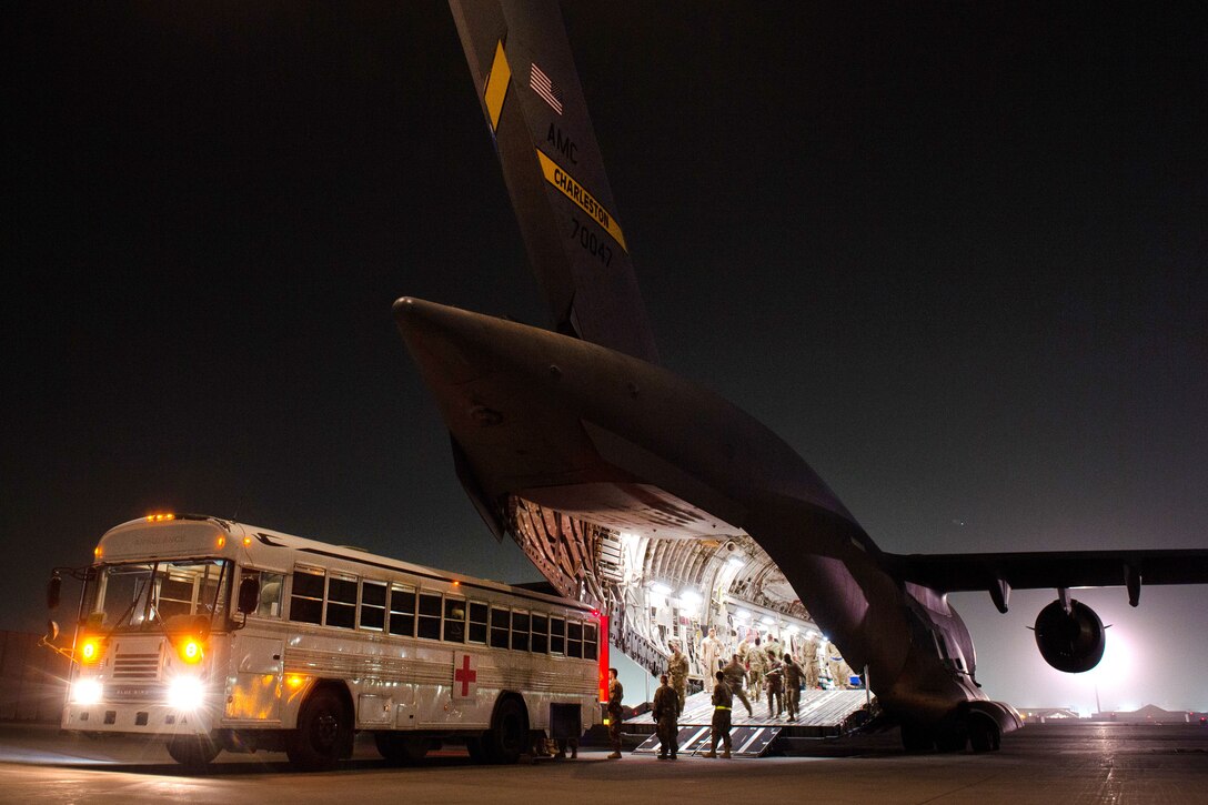 U.S. airmen load injured troops onto a C-17 Globemaster III aircraft on the flightline at Bagram Airfield, Afghanistan, Aug. 8, 2015. The airmen are assigned to the 455th Expeditionary Aeromedical Evacuation Squadron and the 455th Expeditionary Medical Group. The squadron's airmen have the responsibility to evacuate sick and wounded personnel from U.S. Central Command to higher echelons of medical care. U.S. Air Force photo by Tech. Sgt. Joseph Swafford