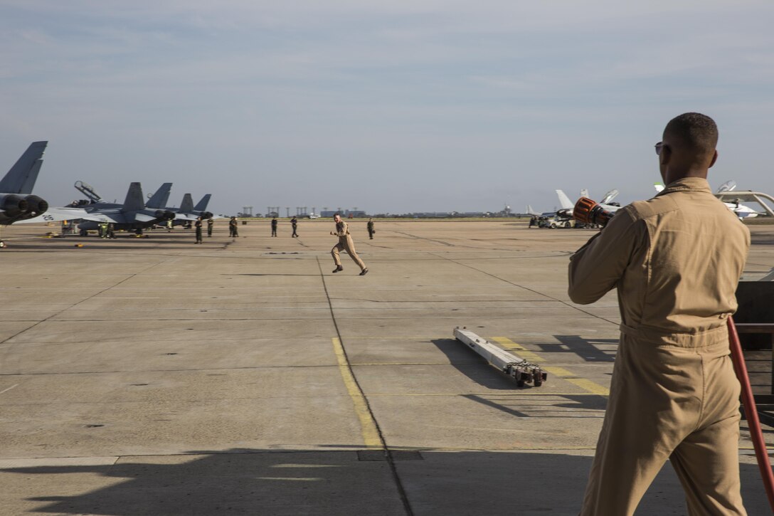 Col. John Farnam, commanding officer of Marine Corps Air Station Miramar, runs across the flightline as a Marine with Aircraft Rescue and Firefighting (ARFF) prepares for a traditional “wet down” aboard MCAS Miramar, California, August 17. Fellow colleagues, family members and ARFF Marines greeted Farnam after his return from his flight as a commanding officer. (U.S. Marine Corps photo by Sgt. Lillian Stephens/Released)