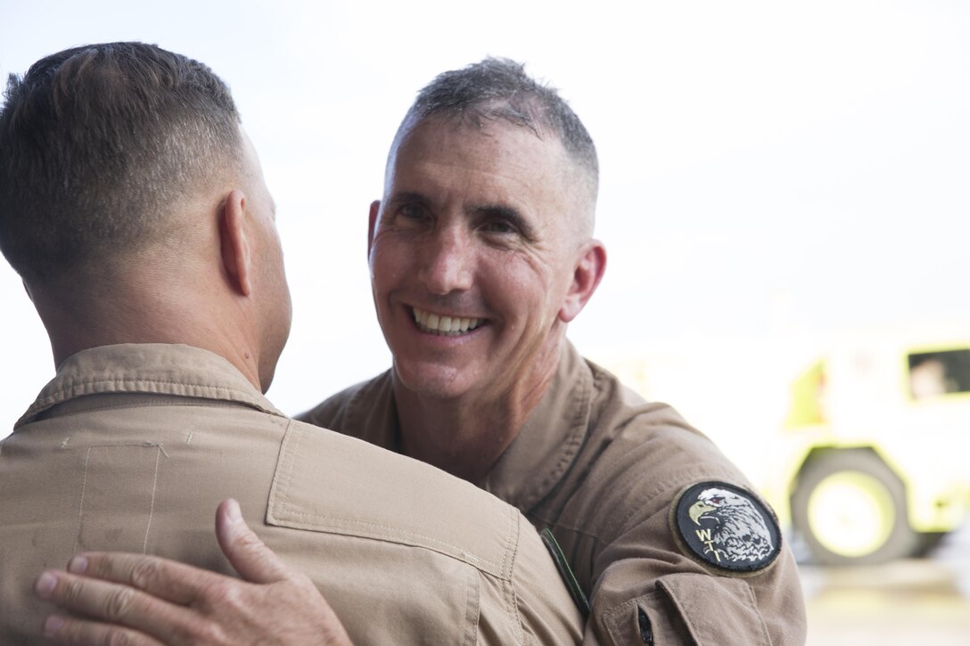 Col. John Farnam, commanding officer of Marine Corps Air Station Miramar, greets a colleague after a traditional “wet down” aboard MCAS Miramar, California, August 17. Family members and Marines celebrated his last flight as MCAS Miramar’s commanding officer. (U.S. Marine Corps photo by Sgt. Lillian Stephens/Released)