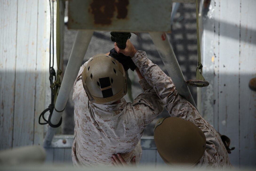 A Marine assigned to Company A, 1st Reconnaissance Battalion, 1st Marine Division, prepares to fast-rope out of a rappel tower as part of Helicopter Rope Suspension Techniques training aboard Marine Corps Base Camp Pendleton, Calif., Aug. 17, 2015. Fast-roping is the most commonly used insertion tactic for Reconnaissance Marines during training or real-life missions.