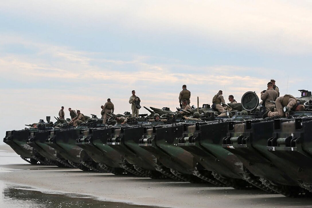 Marines wait for the final check of their amphibious assault vehicles before they train at Onslow Beach on Camp Lejeune, N.C., Aug. 17, 2015. The Marines are assigned to Bravo Company, 2nd Assault Amphibian Battalion.