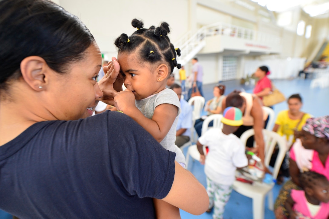 U.S. Petty Officer 3rd Class Krystle Batey interacts with a young patient at a medical site during Continuing Promise 2015 in Santo Domingo, Dominican Republic, Aug. 16, 2015. The exercise focuses on humanitarian-civil assistance, subject matter expert exchanges, medical, dental, veterinary and engineering support and disaster response to partner nations, showing U.S. support to Central and South America and the Caribbean. Batey is a hospital corpsman. U.S. Navy photo by Petty Officer 1st Class Maddelin Angebrand            