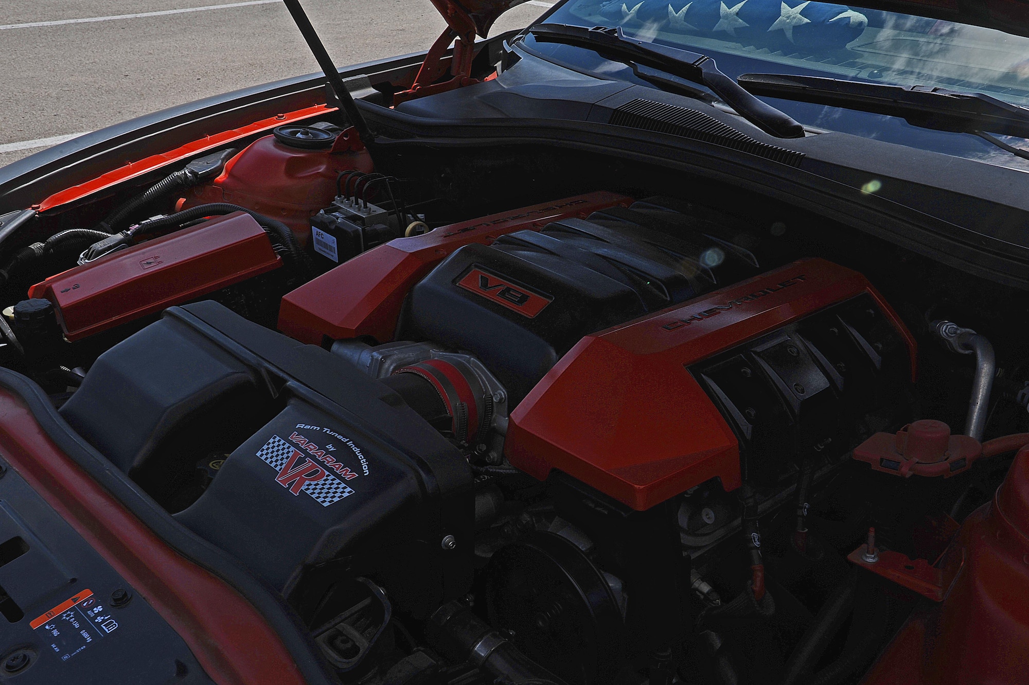 An eight cylinder engine rumbles inside a Chevy Camaro while the sun shines on a folded up American flag at Goodfellow Air Force Base, Aug. 18, 2015. U.S. Air Force Tech. Sgt. Stephen Strong, 315th Training Squadron instructor painted the red pieces on the internal parts of his Camaro. (U.S. Air Force photo by Airman Caelynn Ferguson/Released)