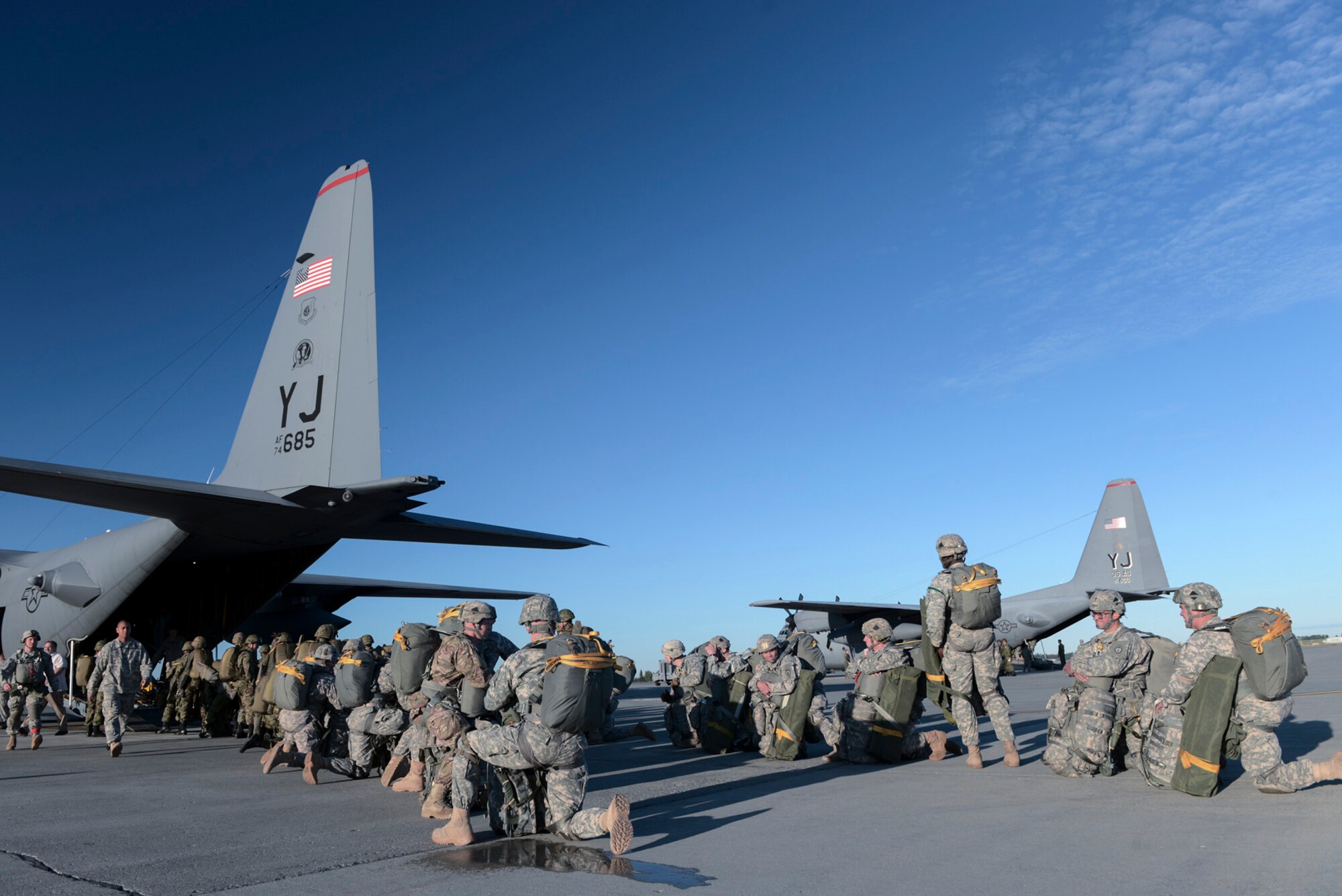U.S. Soldiers with the 1st Battalion (Airborne), 501st Infantry Regiment, and members of the Japan Ground Self-Defense Force wait to board a C-130 Hercules from Yokota Air Base, Japan, during Red Flag-Alaska at Joint Base Elmendorf-Richardson, Alaska, Aug. 12, 2015. More than 60 U.S. Army Soldiers and more than 20 JGSDF members jumped from multiple C-130 Hercules during the training. More than 20 allied countries have participated in Red Flag-Alaska since its conception, improving integration, interoperability and cross-cultural competence. (U.S. Air Force photo by Staff Sgt. Cody H. Ramirez/Released)