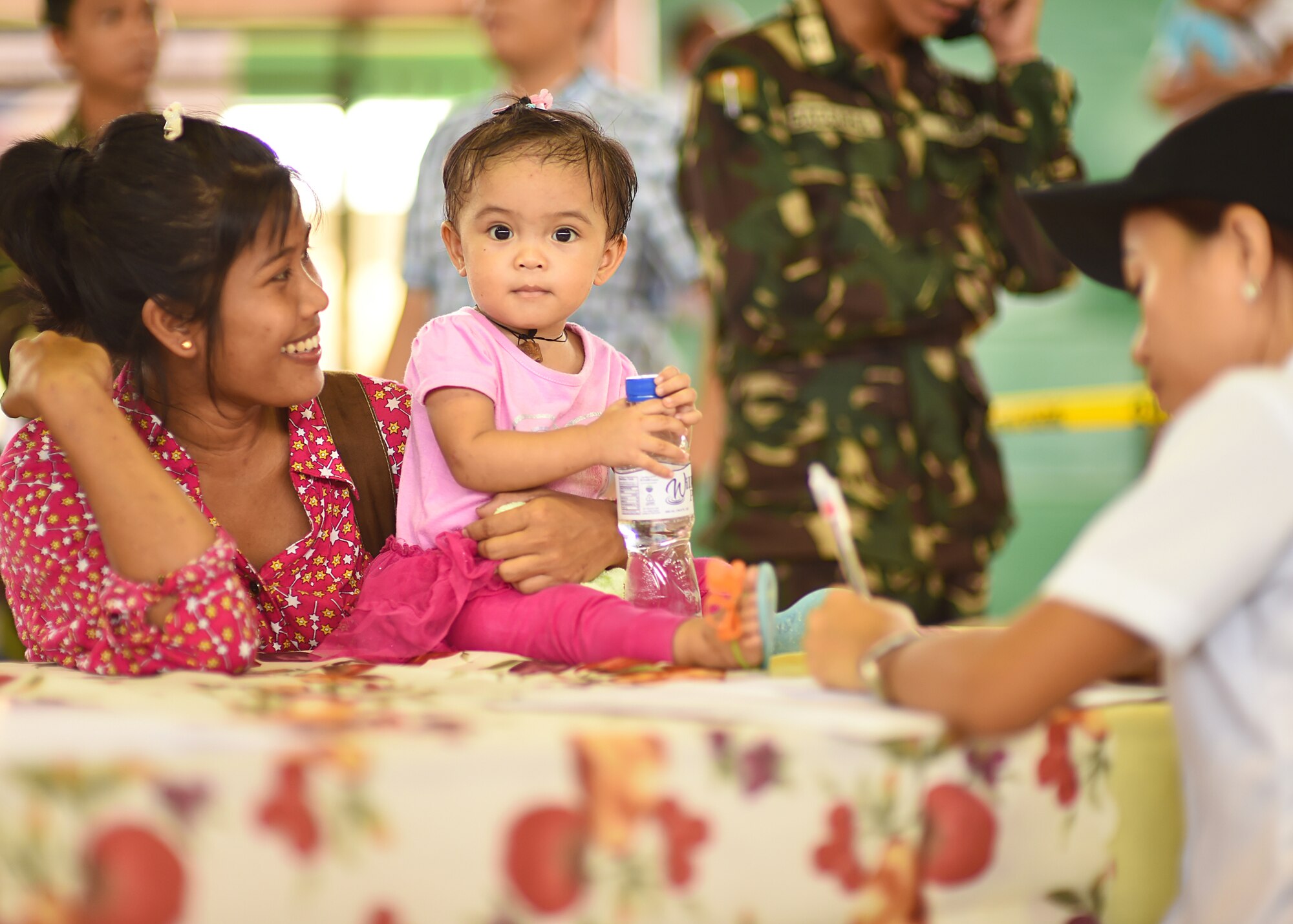 Rayian Carazon and daughter Trica, from Lila, Bohol province, Philippines, process through the register portion of the Health Services Outreach provided as part of the Pacific Angel Philippines mission taking place in Lila, Bohol province, Philippines, Aug. 16, 2015. Pacific Angel is a multilateral humanitarian assistance civil military operation, which improves military-to-military partnerships in the Pacific while also providing medical health outreach, civic engineering projects and subject matter exchanges among partner forces.(U.S. Air Force photo by Tech. Sgt. Aaron Oelrich/Released)