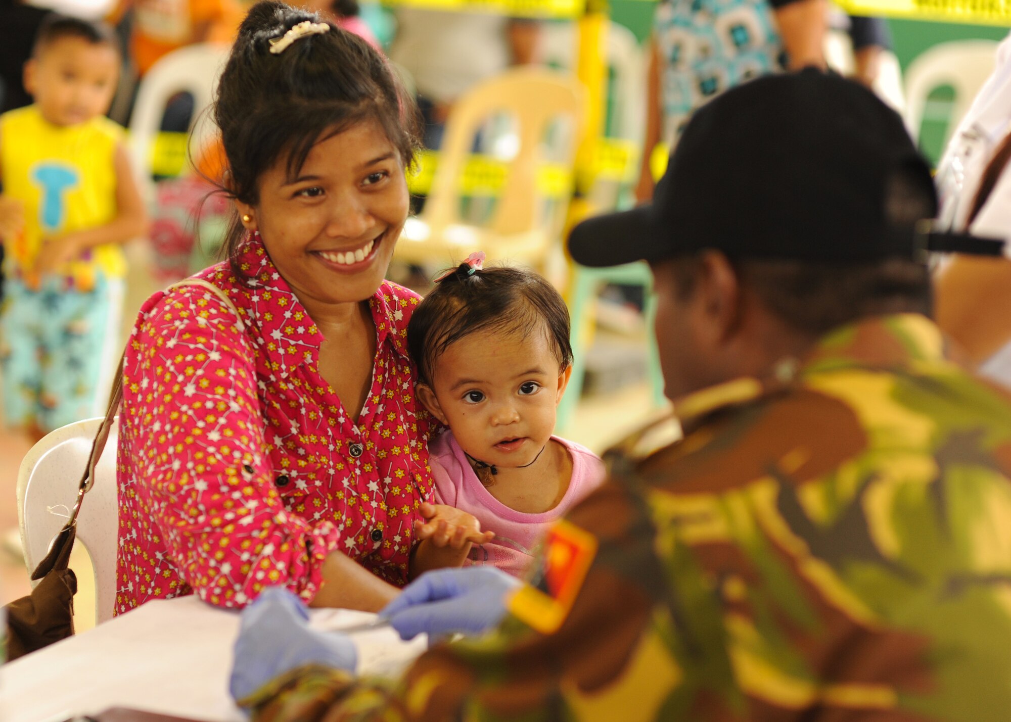 Rayian Carazon and daughter Trica, from Lila, Bohol province, Philippines, talk to Papua New Guinea Defense Force Lt. Charles Namuesl, a family practitioner, during the Health Services Outreach provided as part of the Pacific Angel Philippines mission taking place in Lila, Bohol province, Philippines, Aug. 16, 2015. Pacific Angel is a multilateral humanitarian assistance civil military operation, which improves military-to-military partnerships in the Pacific while also providing medical health outreach, civic engineering projects and subject matter exchanges among partner forces. (U.S. Air Force photo by Tech. Sgt. Aaron Oelrich/Released)