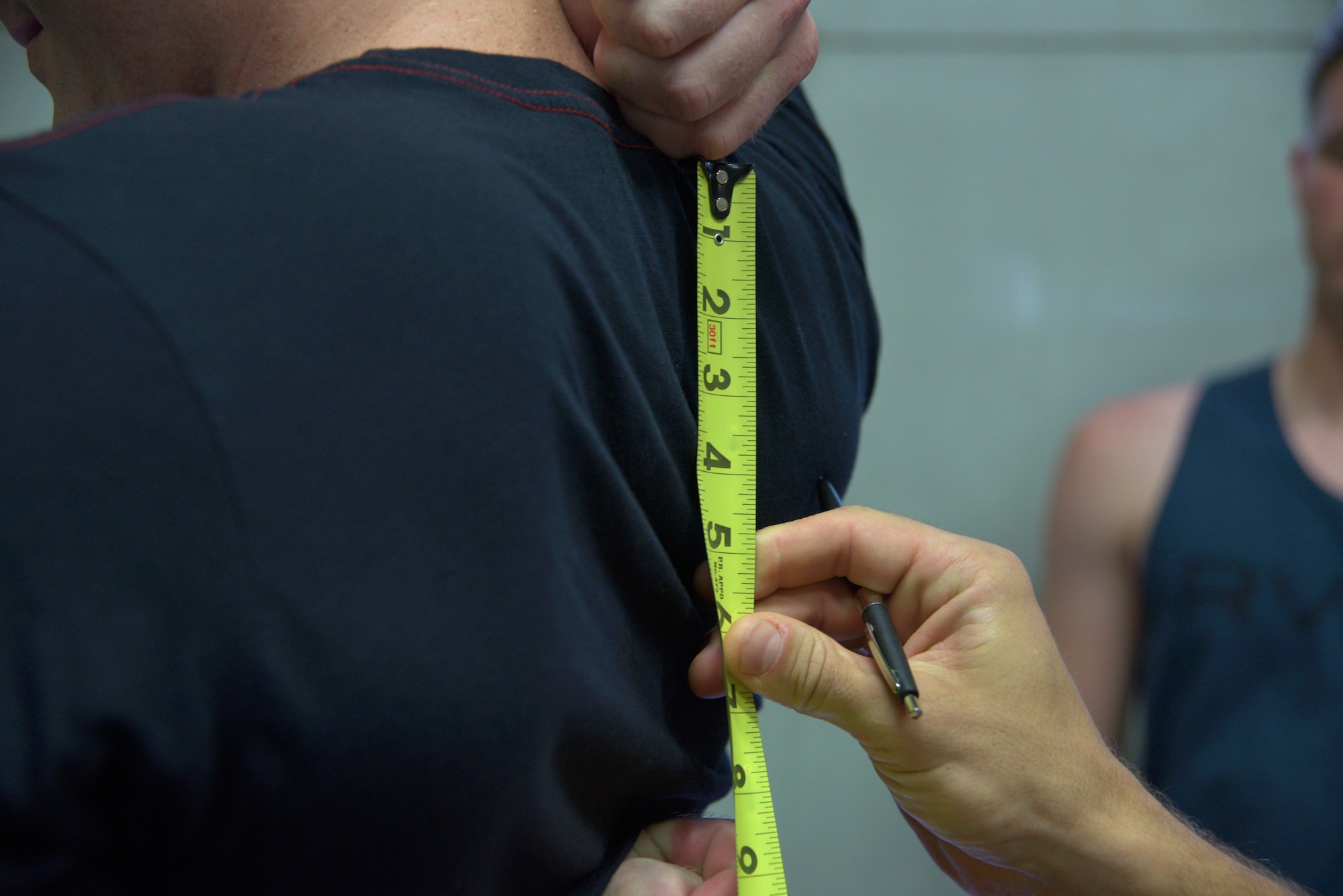 A 35th Medical Operations Squadron member evaluates a shoulder mobility test that measures the distance between hands diagonally crossed in the back at Misawa Air Base, Japan, Aug. 18, 2015. The test is part of a functional movement screening conducted on explosive ordnance disposal members to determine areas of deficit in the body which could lead to potential musculoskeletal injuries. (U.S. Air Force photo by Senior Airman Jose L. Hernandez-Domitilo/Released)
