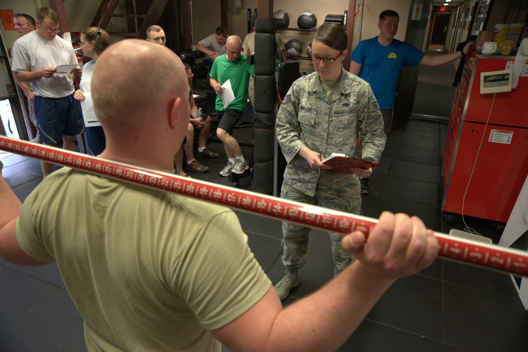 U.S. Air Staff Sgt. Krystina Moore, 35th Medical Operations Squadron NCO in charge of family health, evaluates the stability of a 35th Civil Engineer Squadron explosive ordnance disposal member at Misawa Air Base, Japan, Aug. 18, 2015. Functional movement screenings consisted of truck and core stability, upper and lower extremity flexibility and strength, and overall balance of the body. (U.S. Air Force photo by Senior Airman Jose L. Hernandez-Domitilo/Released)