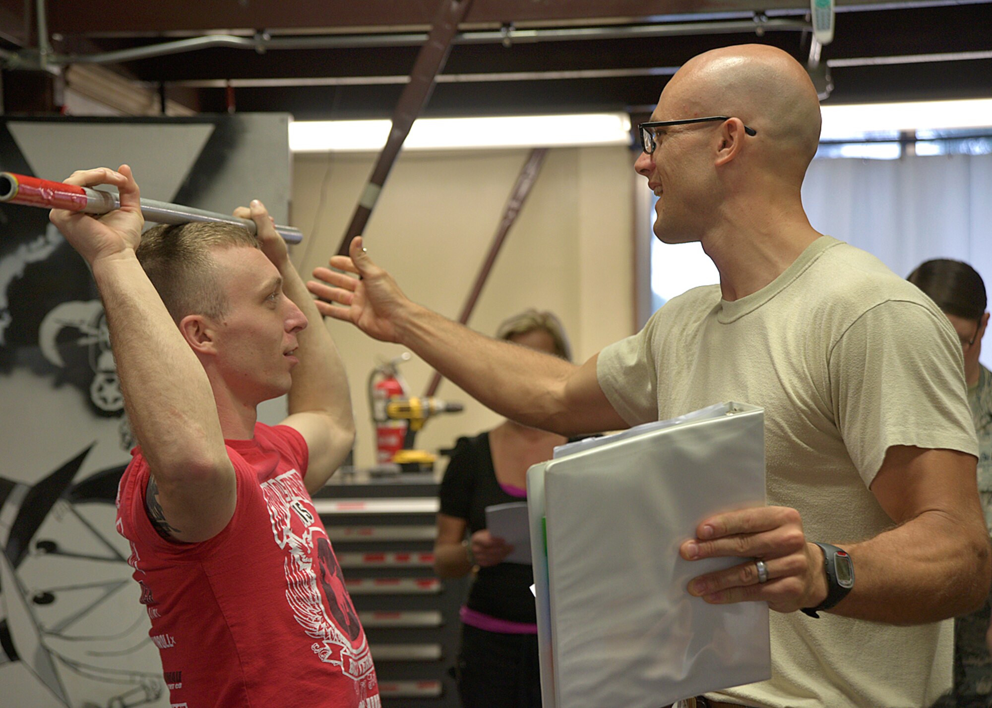 U.S. Air Force Maj. Gabriel Harris, 35th Medical Operations Squadron primary care flight commander, instructs Senior Airman Travis Ditmanson, 35th Civil Engineer Squadron explosive ordnance disposal journeyman, on how to perform a deep squat at Misawa Air Base, Japan, Aug. 18, 2015. Harris is part of a new initiative coined Operator Centered Medical Home, which focuses on bringing medics directly to the units to conduct needs assessments and provide on-the-spot medical advice. (U.S. Air Force photo by Senior Airman Jose L. Hernandez-Domitilo/Released)