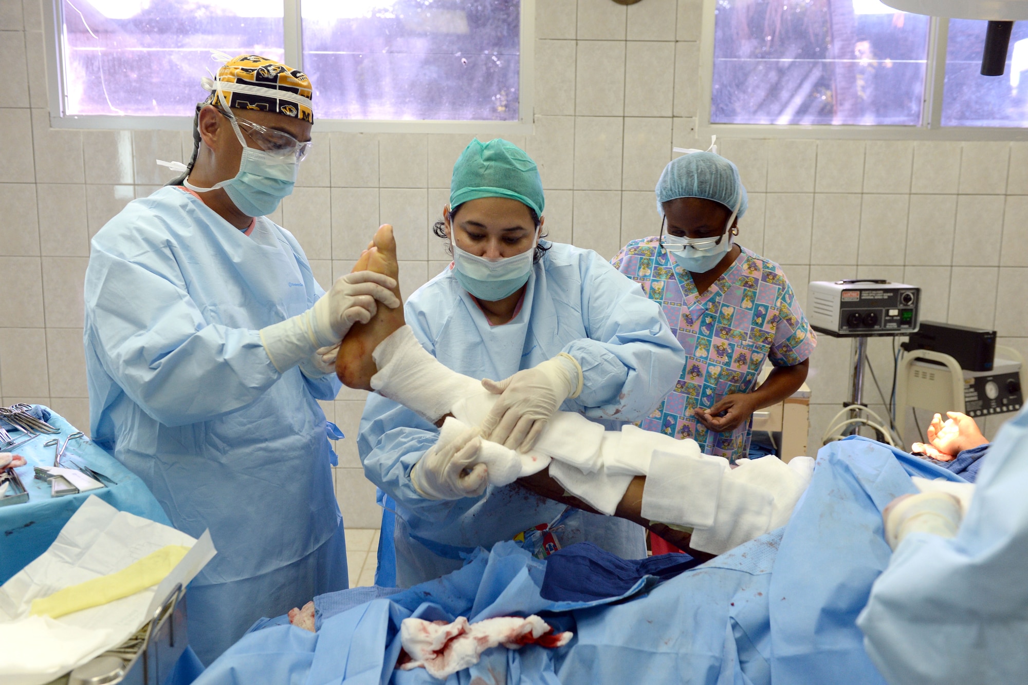 U.S. Air Force Maj. Chol Kim, 88th Aerospace Medical Squadron physician’s assistant, out Wright-Patterson Air Force Base, assists Dr. Ana Mejia, Dr. Salvador Paredes Hospital general surgeon, in the Dr. Salvador Paredes Hospital in Trujillo, Honduras, August 10, 2015, as she wraps the injured leg of a soldier from the Honduran Army’s 15th Battalion. The Honduran solider was one of 13 involved in an explosion at his base. Chol is in Honduras as part of the New Horizons Honduras 2015 training exercise. 

New Horizons was launched in the 1980s and is an annual joint humanitarian assistance exercise that U.S. Southern Command conducts with a partner nation in Central America, South America or the Caribbean. The exercise improves joint training readiness of U.S. and partner nation civil engineers, medical professionals and support personnel through humanitarian assistance activities.

(U.S. Air Force photo by Capt. David J. Murphy/Released)
