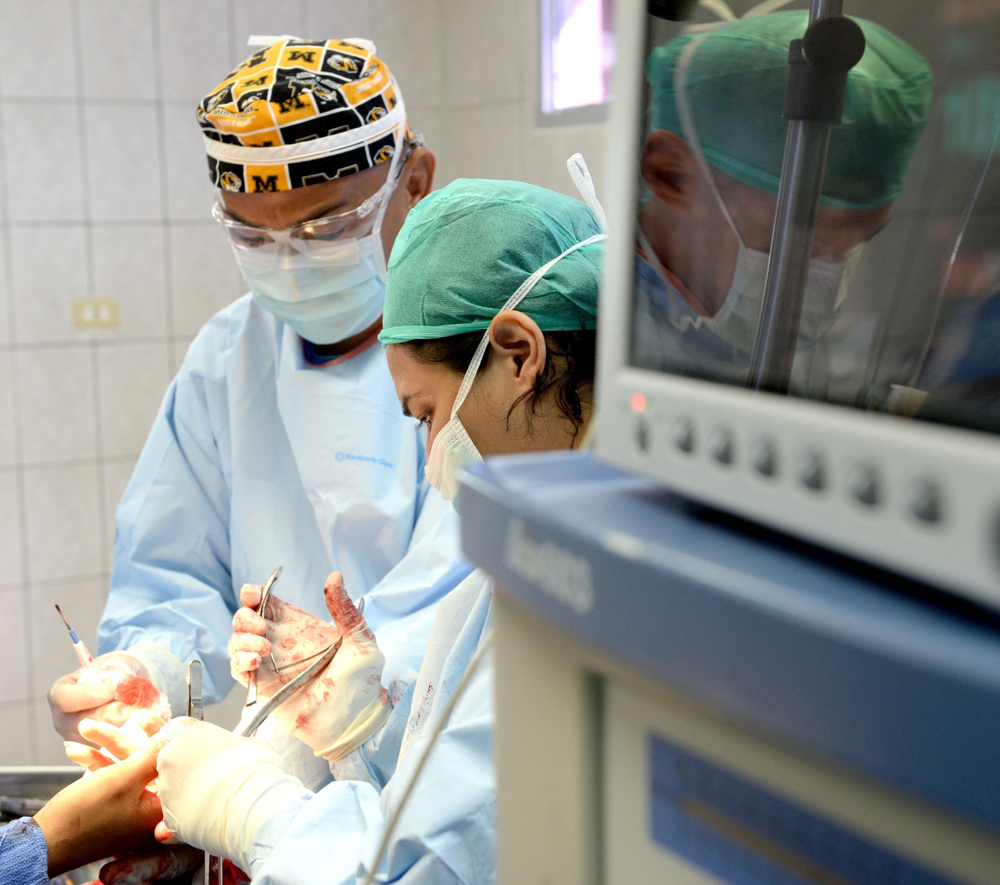 U.S. Air Force Maj. Chol Kim, 88th Aerospace Medical Squadron physician’s assistant, out Wright-Patterson Air Force Base, assists Dr. Ana Mejia, Dr. Salvador Paredes Hospital general surgeon, in the Dr. Salvador Paredes Hospital in Trujillo, Honduras, August 10, 2015, as she performs surgery on the hand of a soldier from the Honduran Army’s 15th Battalion. The Honduran solider was one of 13 involved in an explosion at his base. Chol is in Honduras as part of the New Horizons Honduras 2015 training exercise. 

New Horizons was launched in the 1980s and is an annual joint humanitarian assistance exercise that U.S. Southern Command conducts with a partner nation in Central America, South America or the Caribbean. The exercise improves joint training readiness of U.S. and partner nation civil engineers, medical professionals and support personnel through humanitarian assistance activities.

(U.S. Air Force photo by Capt. David J. Murphy/Released)