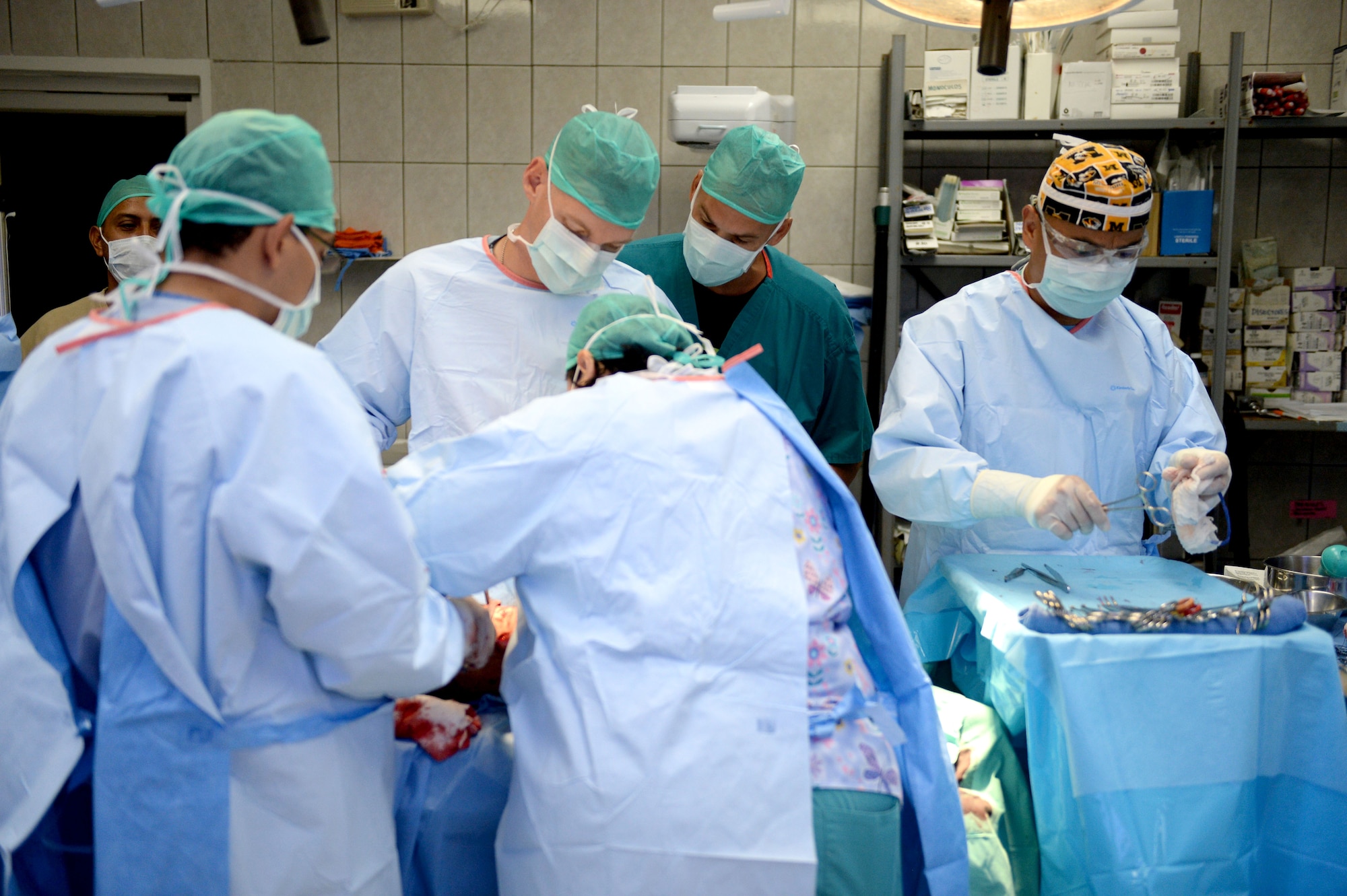 U.S. Air Force medical personnel work hand in hand with Honduran doctors to perform an emergency surgical procedure on a Honduran Army soldier with the 15th Battalion at the Dr. Salvador Paredes Hospital, August 10, 2015. The Honduran solider was one of 13 involved in an explosion at his base. The medical personnel are in Honduras as part of the New Horizons Honduras 2015 training exercise. 

New Horizons was launched in the 1980s and is an annual joint humanitarian assistance exercise that U.S. Southern Command conducts with a partner nation in Central America, South America or the Caribbean. The exercise improves joint training readiness of U.S. and partner nation civil engineers, medical professionals and support personnel through humanitarian assistance activities.

(U.S. Air Force photo by Capt. David J. Murphy/Released)