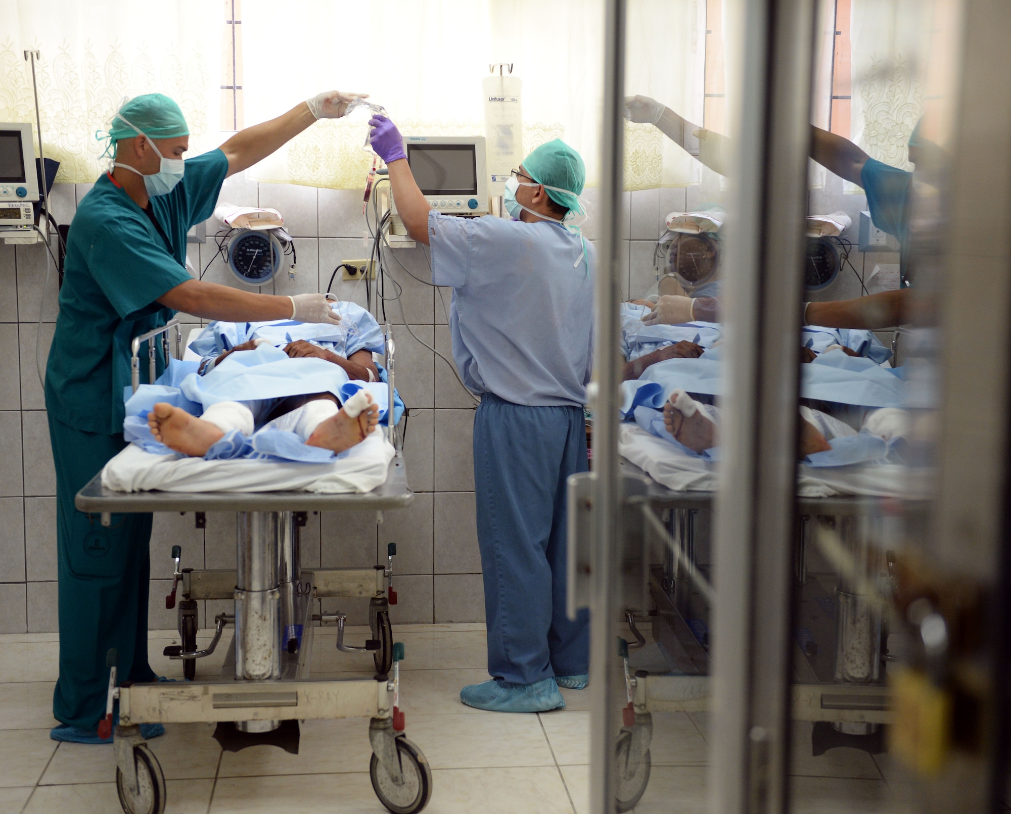 U.S. Air Force Maj. Frederick Grois, 779th Medical Operations Squadron anesthesiologist, out of Joint Base Andrews, Md., assists with post-surgery treatment of a Honduran Army soldier with the 15th Battalion who had emergency surgery at the Dr. Salvador Paredes Hospital, August 10, 2015. The Honduran solider was one of 13 injured in an explosion at his base. Grois is in Honduras as part of the New Horizons Honduras 2015 training exercise. 

New Horizons was launched in the 1980s and is an annual joint humanitarian assistance exercise that U.S. Southern Command conducts with a partner nation in Central America, South America or the Caribbean. The exercise improves joint training readiness of U.S. and partner nation civil engineers, medical professionals and support personnel through humanitarian assistance activities.

(U.S. Air Force photo by Capt. David J. Murphy/Released)