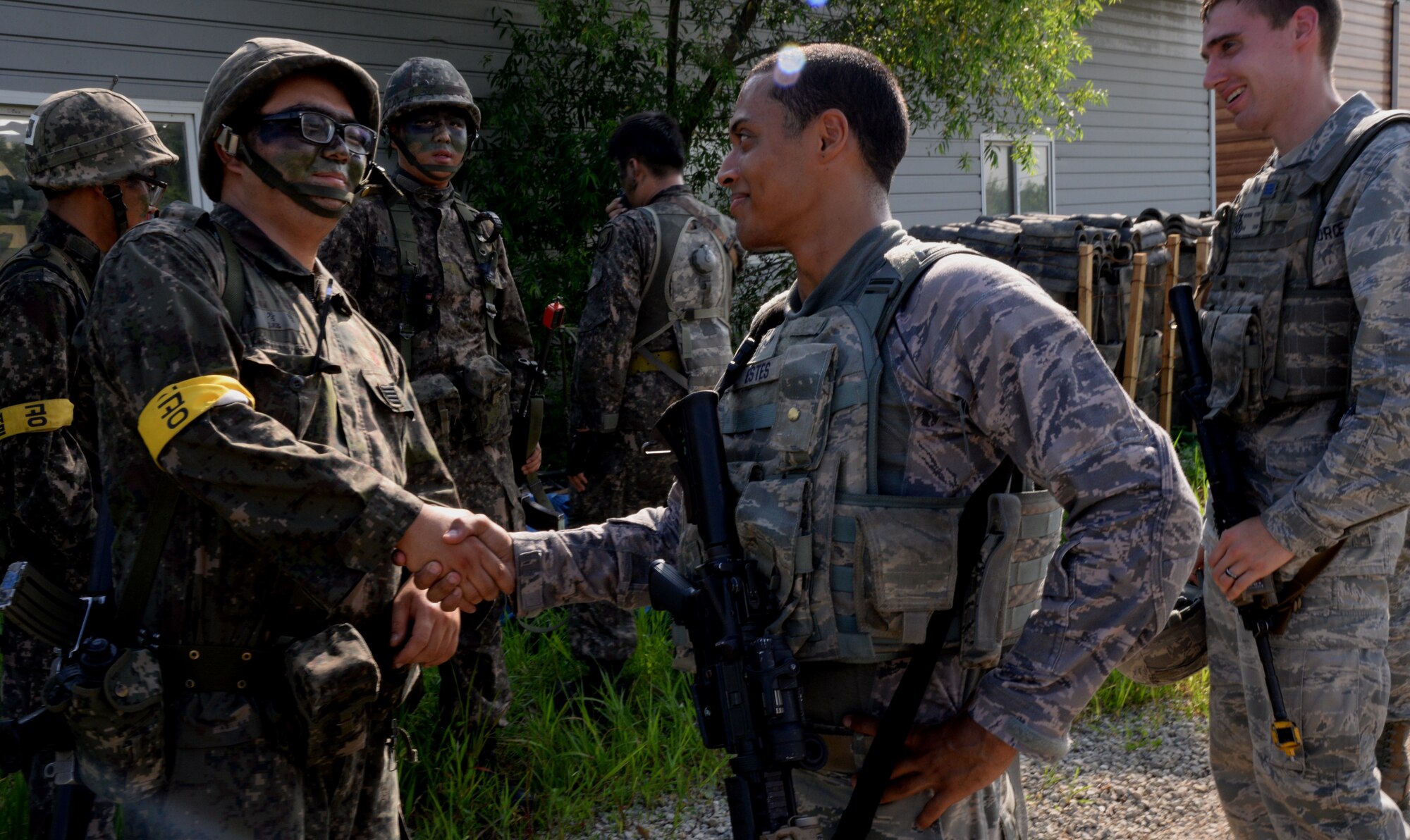 Republic of Korea Army Specialist Changhyeop Lee, shakes hands with Airman 1st Class Donte Estes, 51st Security Forces Squadron patrolman, Aug. 18, 2015, near Pyeongtaek, South Korea. Members of the 51st SFS and ROKA worked together to perform multiple patrols during the simulated exercise in an effort to bolster combat readiness. (U.S. Air Force photo by Staff Sgt. Benjamin Sutton) 