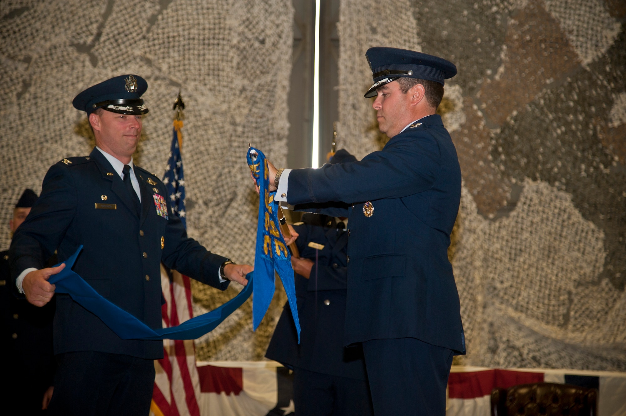 Col. Dagvin Anderson, 58th Special Operations Wing commander, and Col. Jonathan Duncan, 336th Training Group commander, furl the 36th Rescue Flight guidon Aug. 14, 2015, at Fairchild Air Force Base, Wash. The furling of the flight guidon flag symbolizes the end of the unit's status as a flight. The flight was then re-designated as a squadron. (U.S. Air Force photo/Airman 1st Class Taylor Bourgeous)