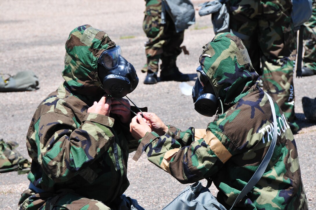 Airmen from the 161st Civil Engineer Squadron use the buddy system while donning their chemical protection ensemble during ability to survive and operate training at Camp Navajo, Ariz., Aug. 5. The training week included weapons qualification, self-aid buddy care, ability to survive and operate, land navigation and diversity training.  (U.S. Air National Guard photo by Master Sgt. Kelly Deitloff)