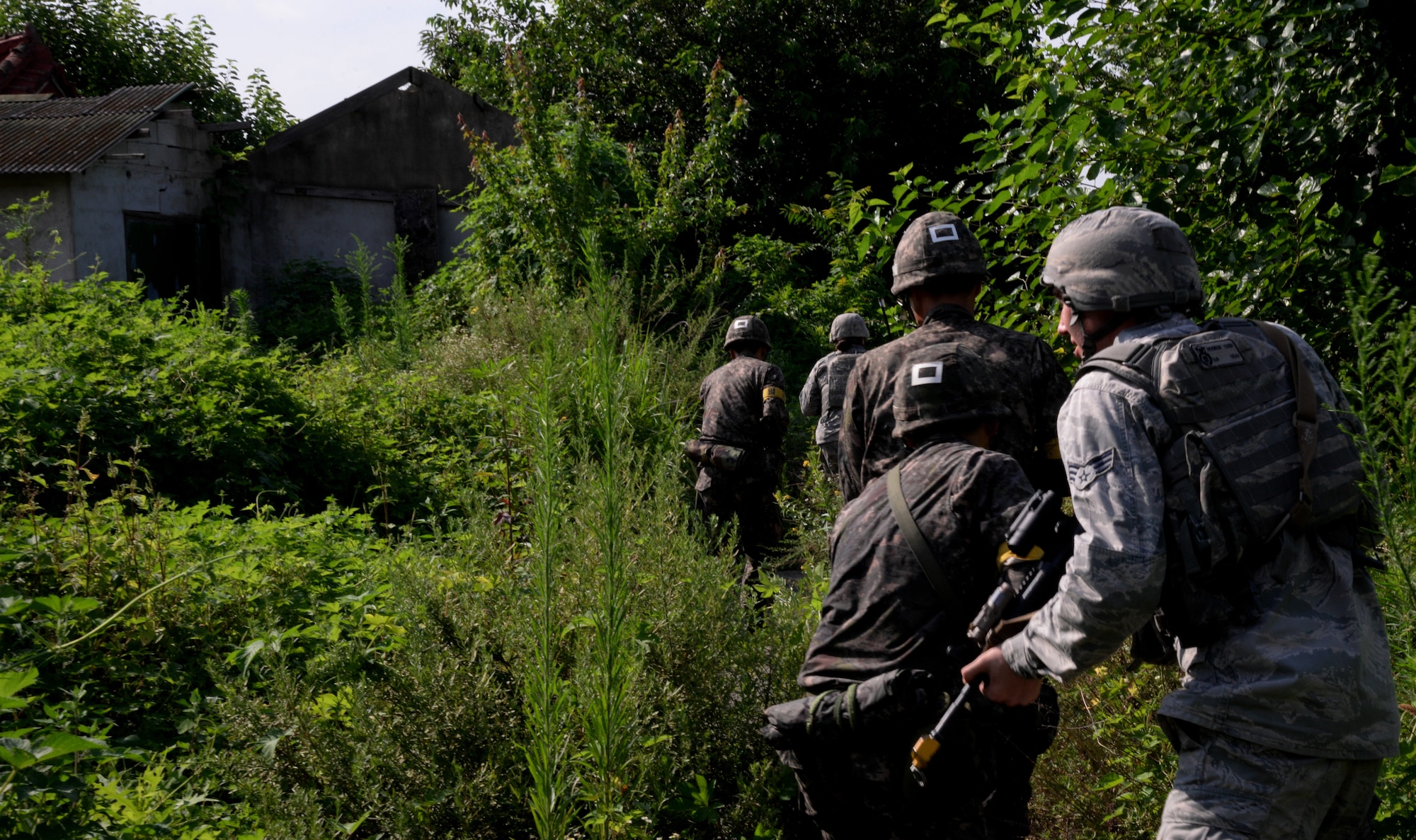 Members of a combined U.S. Air Force and Republic of Korea Army tactical response team patrol along the perimeter of an area during an exercise simulation Aug. 18, 2015, near Pyeongtaek, South Korea. Members of the 51st Security Forces Squadron and ROKA worked together throughout the day in an effort to bolster combat readiness. (U.S. Air Force photo by Staff Sgt. Benjamin Sutton) 