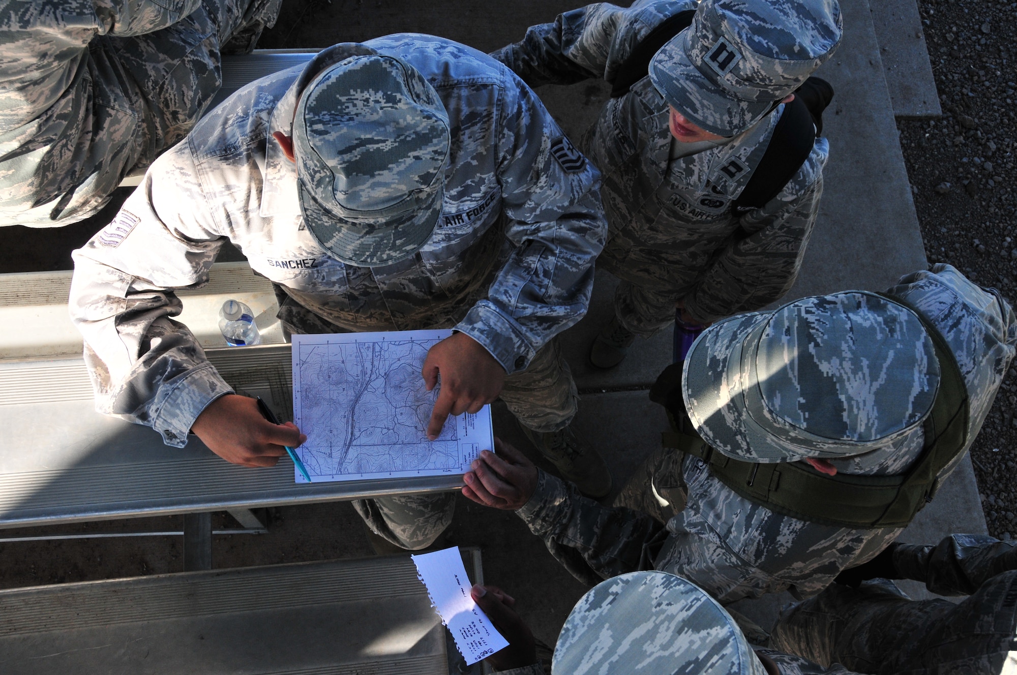 Tech. Sgt. Jimmy Sanchez plots out points on a topographical map during land navigation training with his team, Capt. Tauna Roberts, Airman 1st Class Clyde Samilton and Airman 1st Class Wendell Van Duyne at Camp Navajo, Ariz., Aug. 5. Airmen from the 161st Air Refueling Wing participated in ancillary training which included weapons qualification, self-aid buddy care, ability to survive and operate, land navigation and diversity training.  (U.S. Air National Guard photo by Master Sgt. Kelly Deitloff)